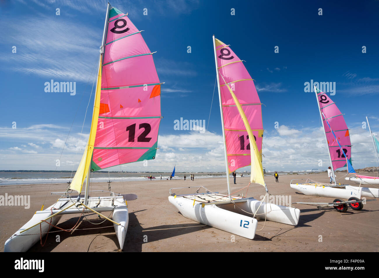 Bateaux Catamaran dans une rangée sur la plage avec un ciel bleu Banque D'Images