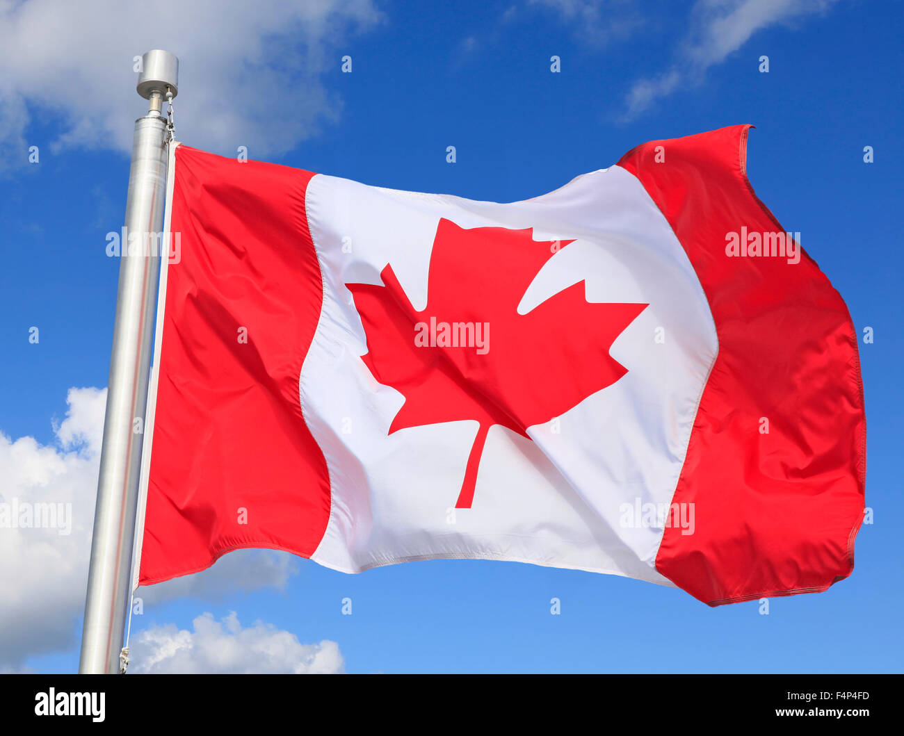 Brandir le drapeau canadien sur le vent avec ciel bleu et des nuages blancs de fond Banque D'Images