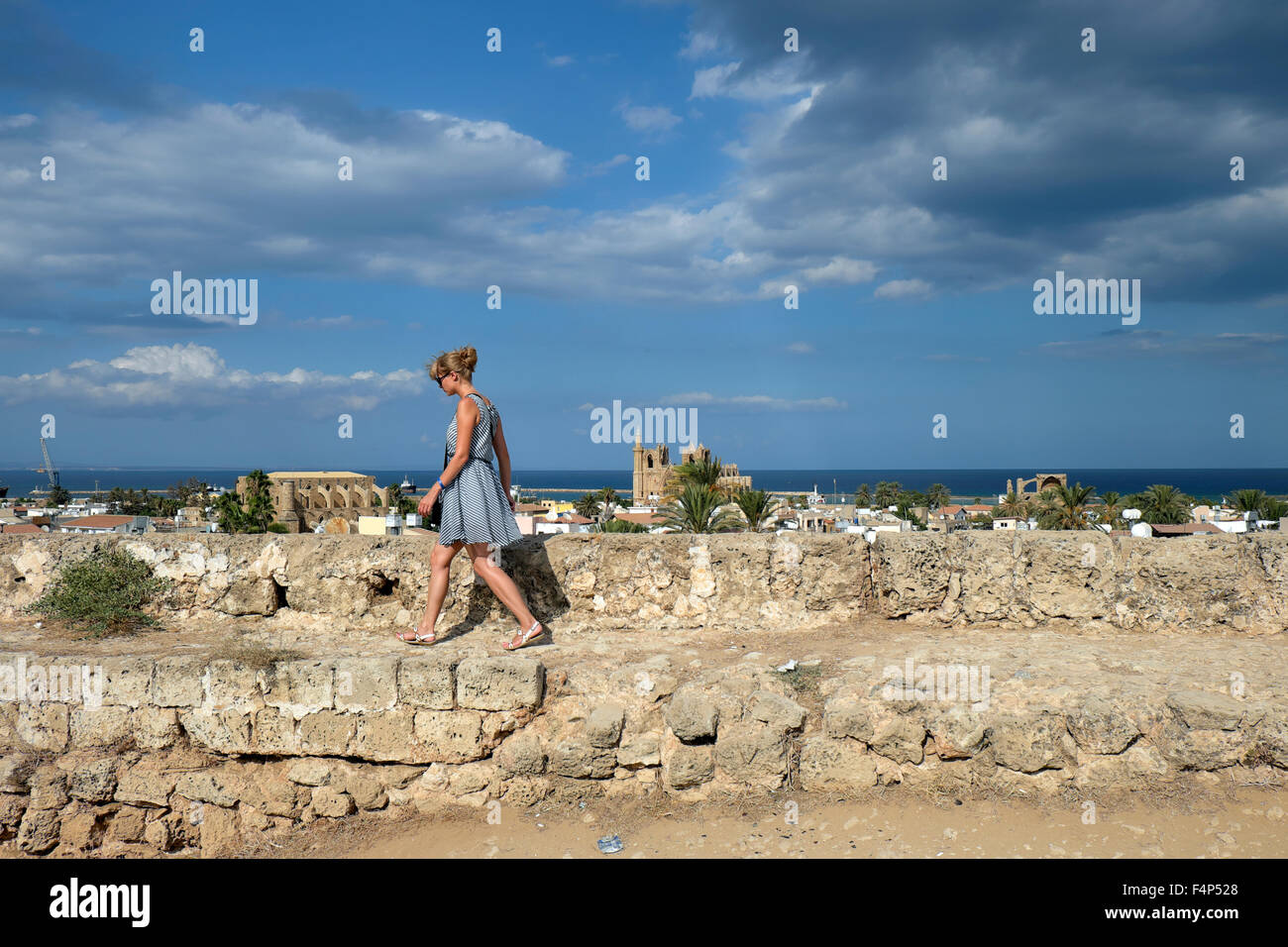 Une jeune femme attrayante promenade touristique dans l'ancien mur pour une vue de la ville de Famagouste Chypre du Nord KATHY DEWITT Banque D'Images