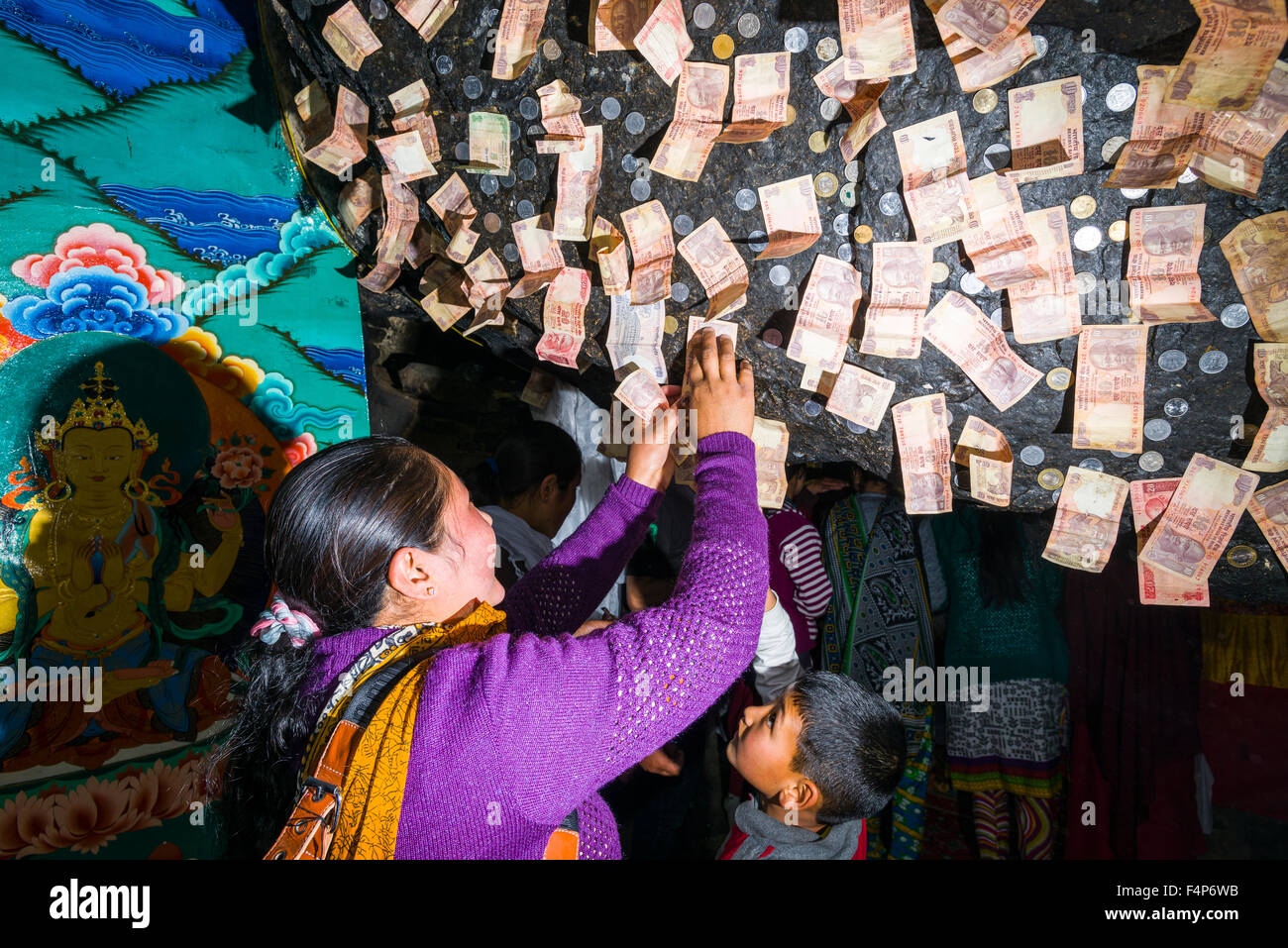 Les pèlerins sont offrant de l'argent à gotsang cave en collant à la roche Banque D'Images