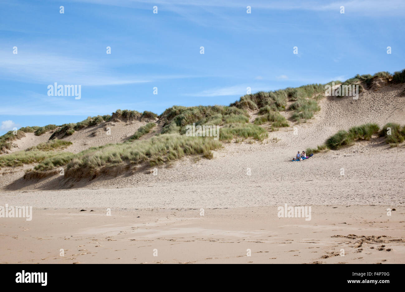 Couple pique-nique dans les dunes de sable de Crantock Beach en octobre, Cornouailles, Angleterre. ROYAUME-UNI Banque D'Images