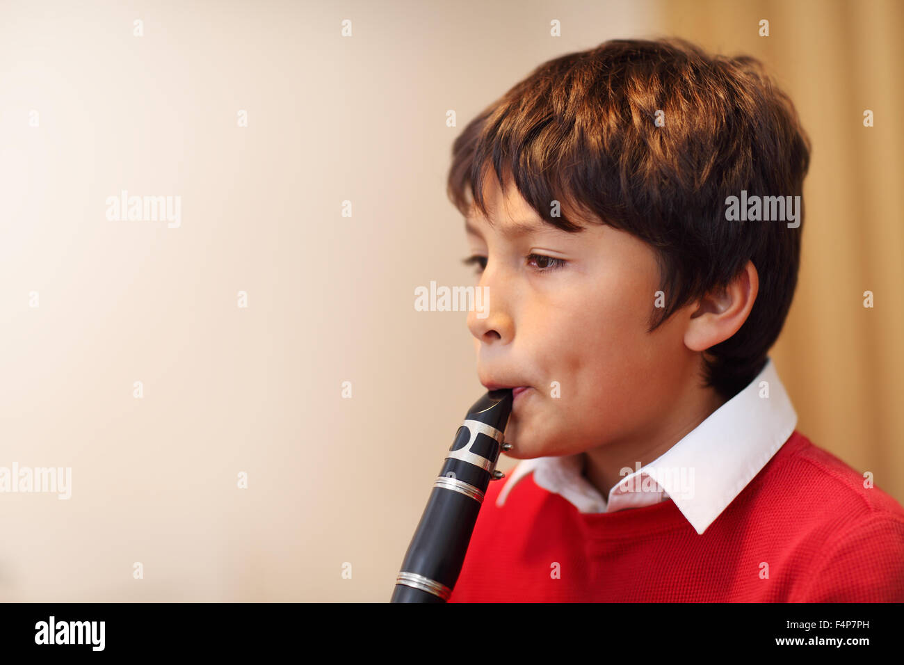 Jeune garçon jouant de la clarinette - profondeur de champ - des tons chauds. Copy space Banque D'Images