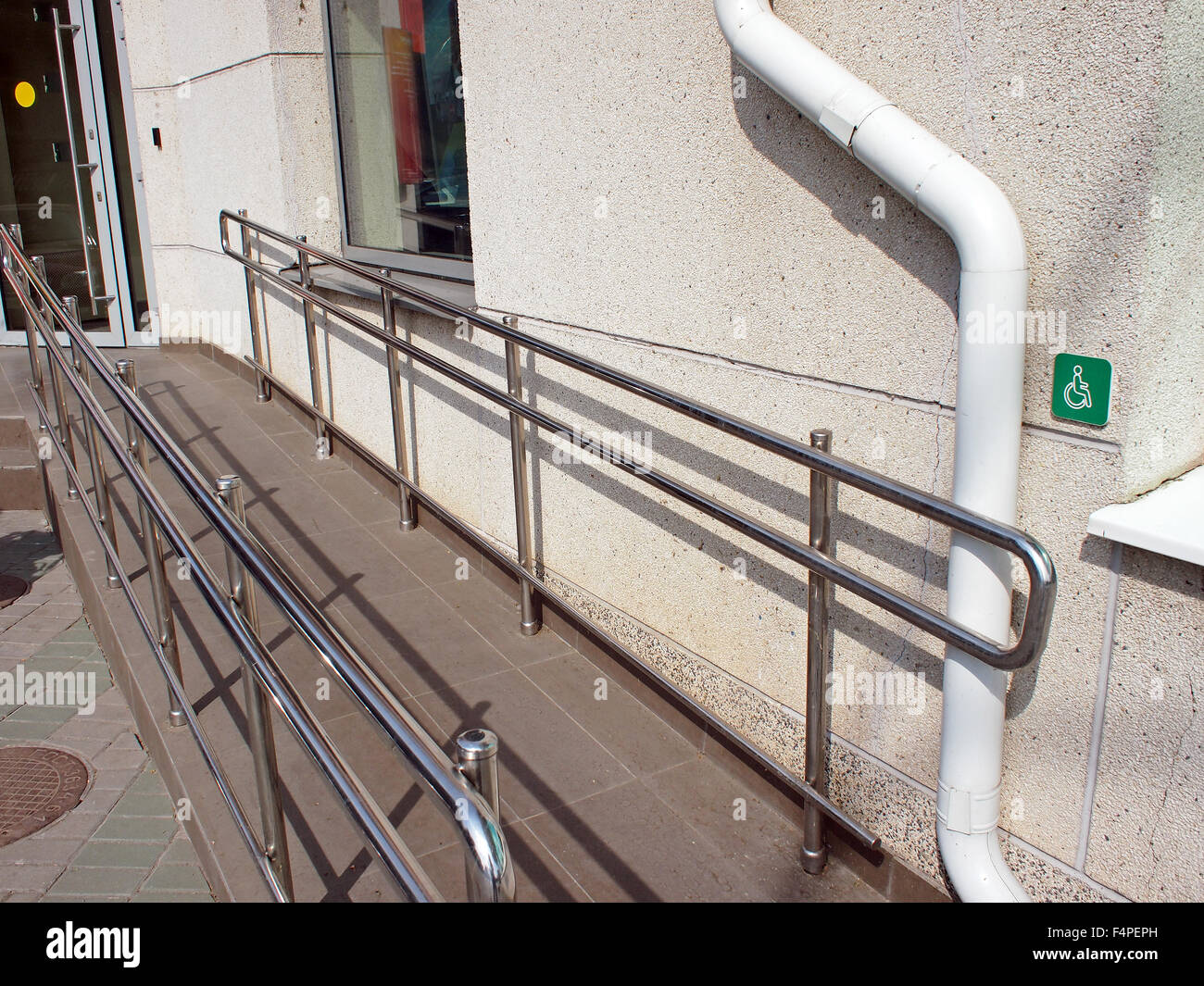 Rampe pour handicapés avec rampe en métal à l'entrée d'un immeuble de bureaux dans la région de sunny summer day Banque D'Images