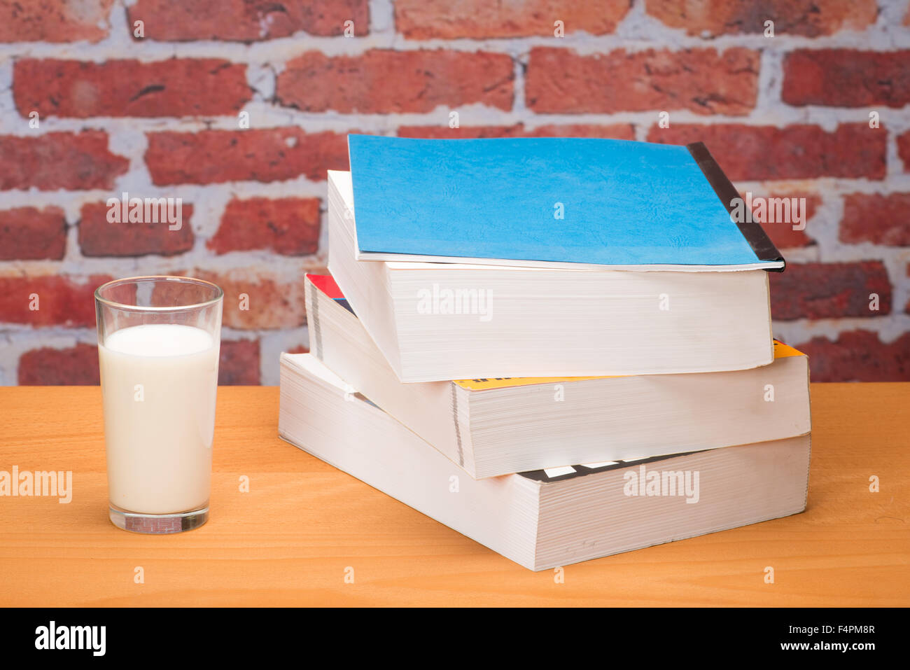 Livre pour l'école verre de lait en face de mur de brique Photo Stock -  Alamy