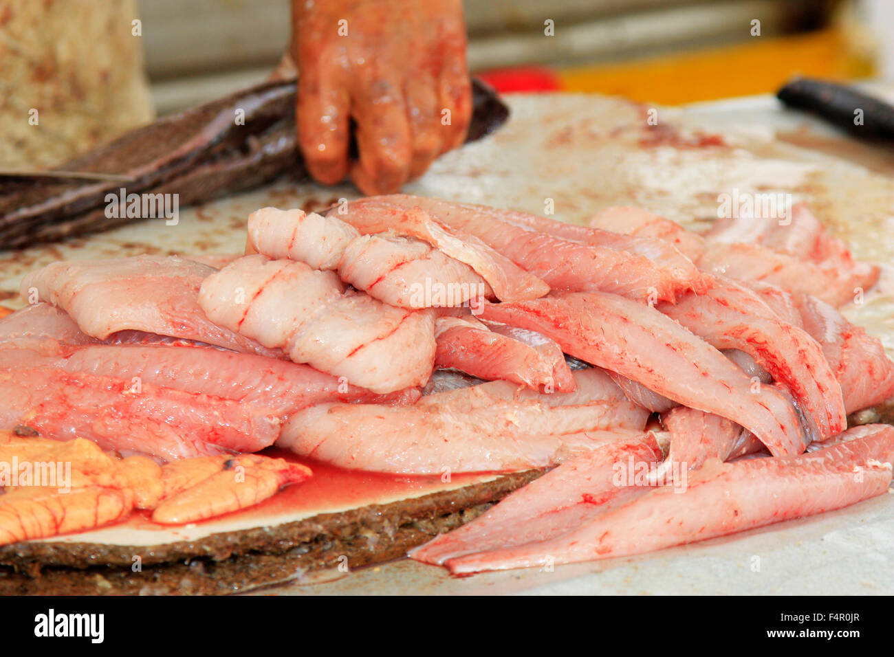 Un homme de fileter le poisson fraîchement pêché Banque D'Images