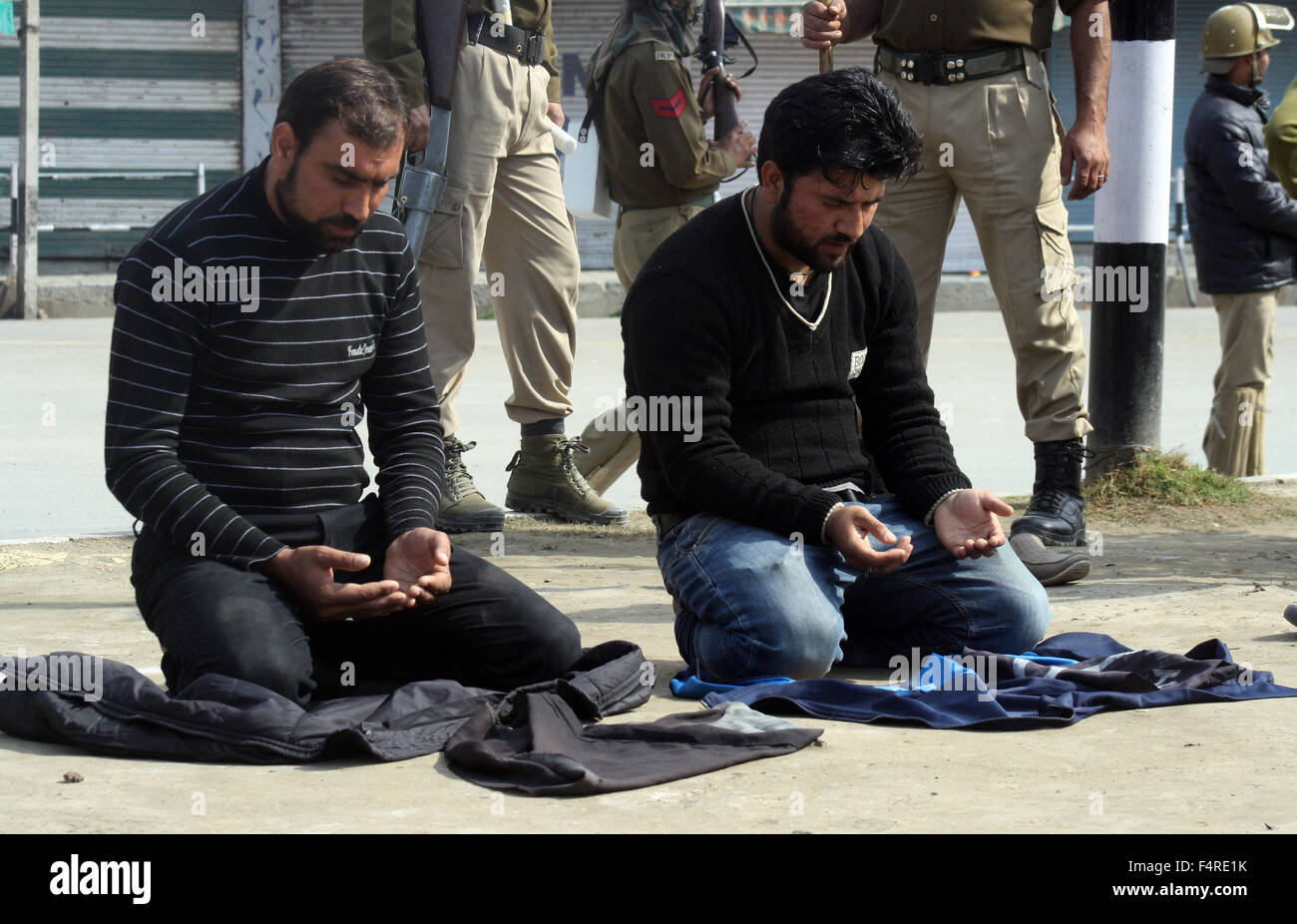 Srinagar, Inde. 22 octobre, 2015. Kashmiri musulman chiite dévots prie sur la route en tant que policiers indiens s'guatd pendant les offices religieux sur le 8 Muharram procession, imposé des restrictions dans certaines parties de Srinagar, la capitale d'été du cachemire, pour contrecarrer les Mouharram processions. Les restrictions imposées par les autorités dans certaines régions de Srinagar. Credit : Sofi suhail/Alamy Live News Banque D'Images