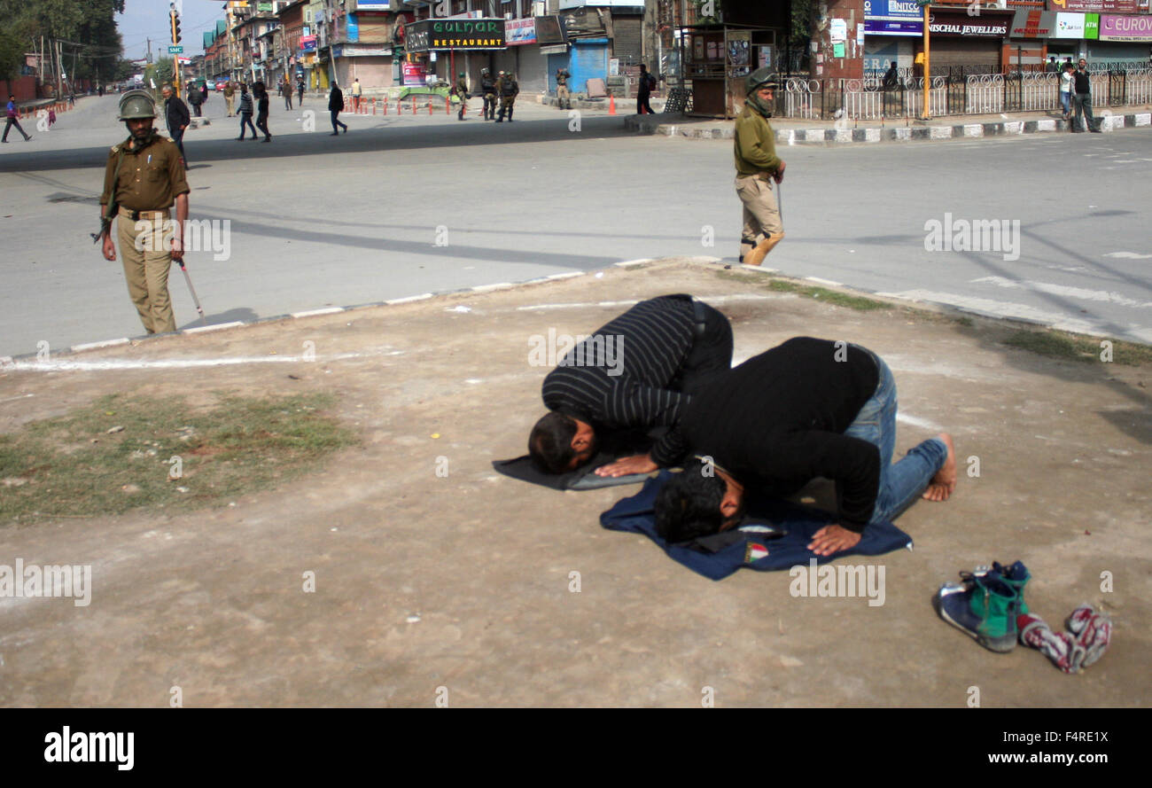 Srinagar, Inde. 22 octobre, 2015. Kashmiri musulman chiite dévots prie sur la route en tant que policiers indiens s'guatd pendant les offices religieux sur le 8 Muharram procession, imposé des restrictions dans certaines parties de Srinagar, la capitale d'été du cachemire, pour contrecarrer les Mouharram processions. Les restrictions imposées par les autorités dans certaines régions de Srinagar. Credit : Sofi suhail/Alamy Live News Banque D'Images