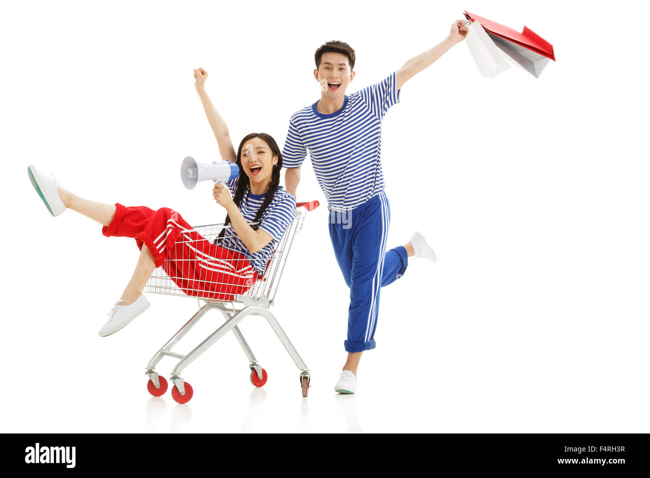 Happy young couple pousser un panier Banque D'Images