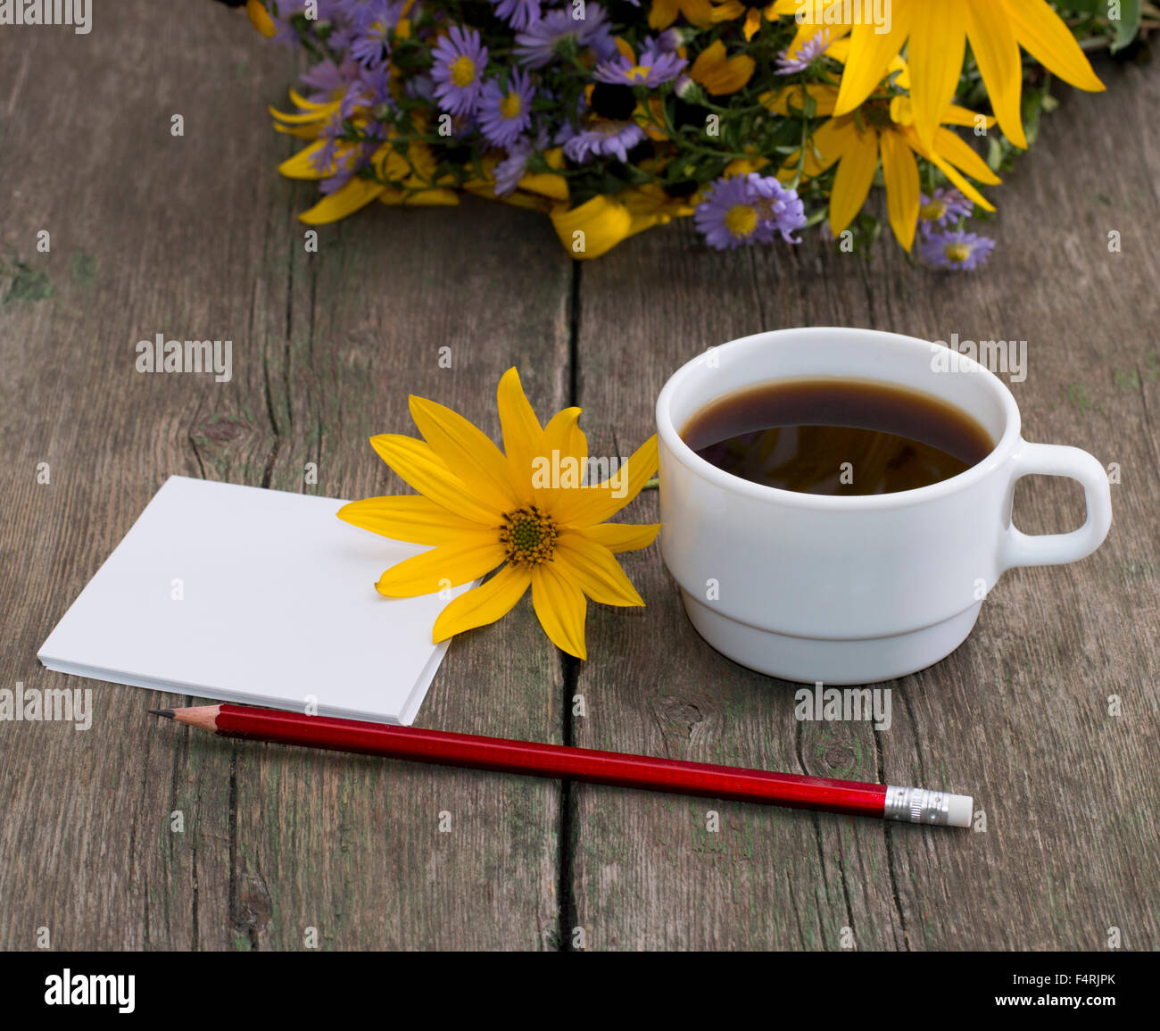 Le café, fleur jaune, un crayon de papier et de fleurs sauvages, une nature morte Banque D'Images