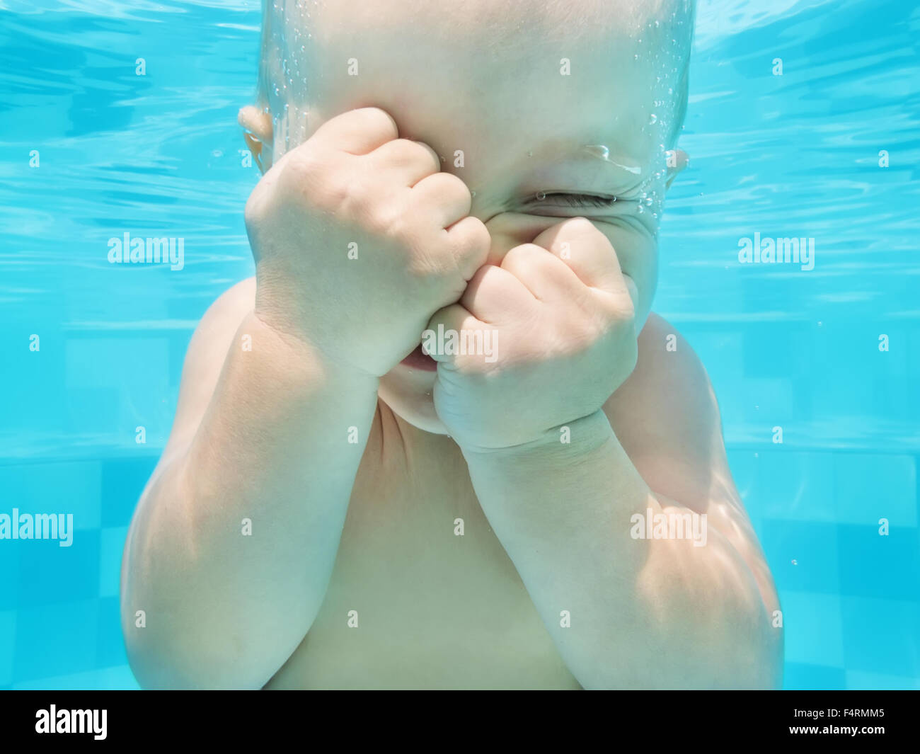 Funny face portrait de petit bébé garçon ayant une leçon en bleu piscine - natation et plongée sous l'eau avec plaisir. Banque D'Images