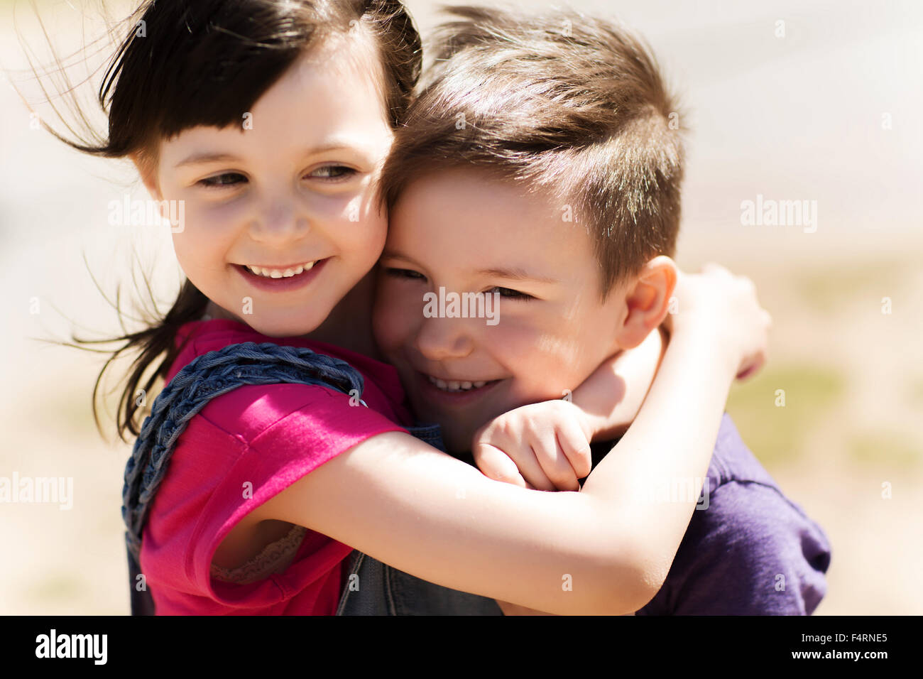 Deux enfants heureux hugging outdoors Banque D'Images
