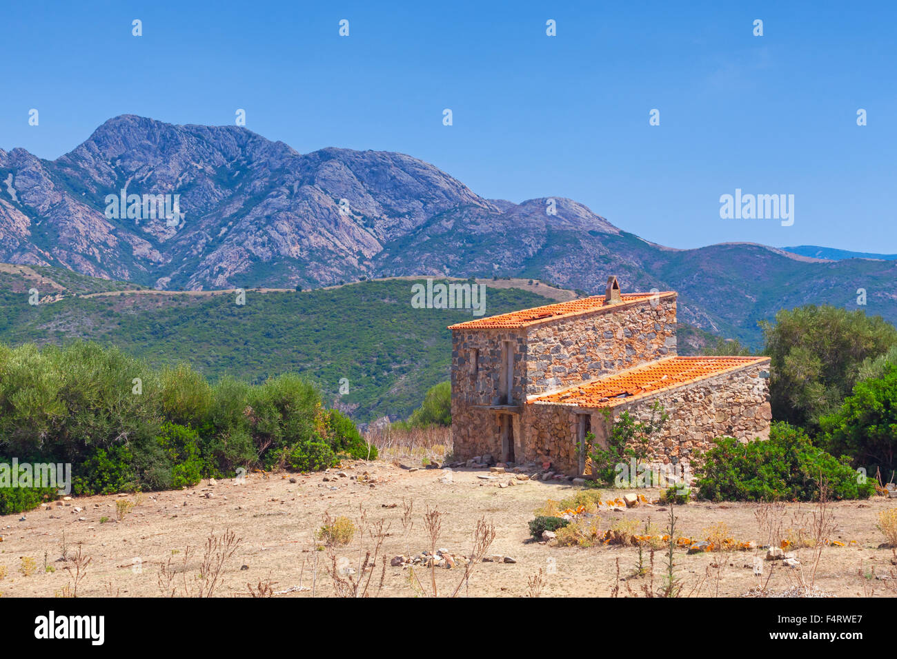 Paysage rural avec petite maison en pierre abandonnée et les montagnes à l'horizon. La région de Piana, Corse du Sud, France Banque D'Images