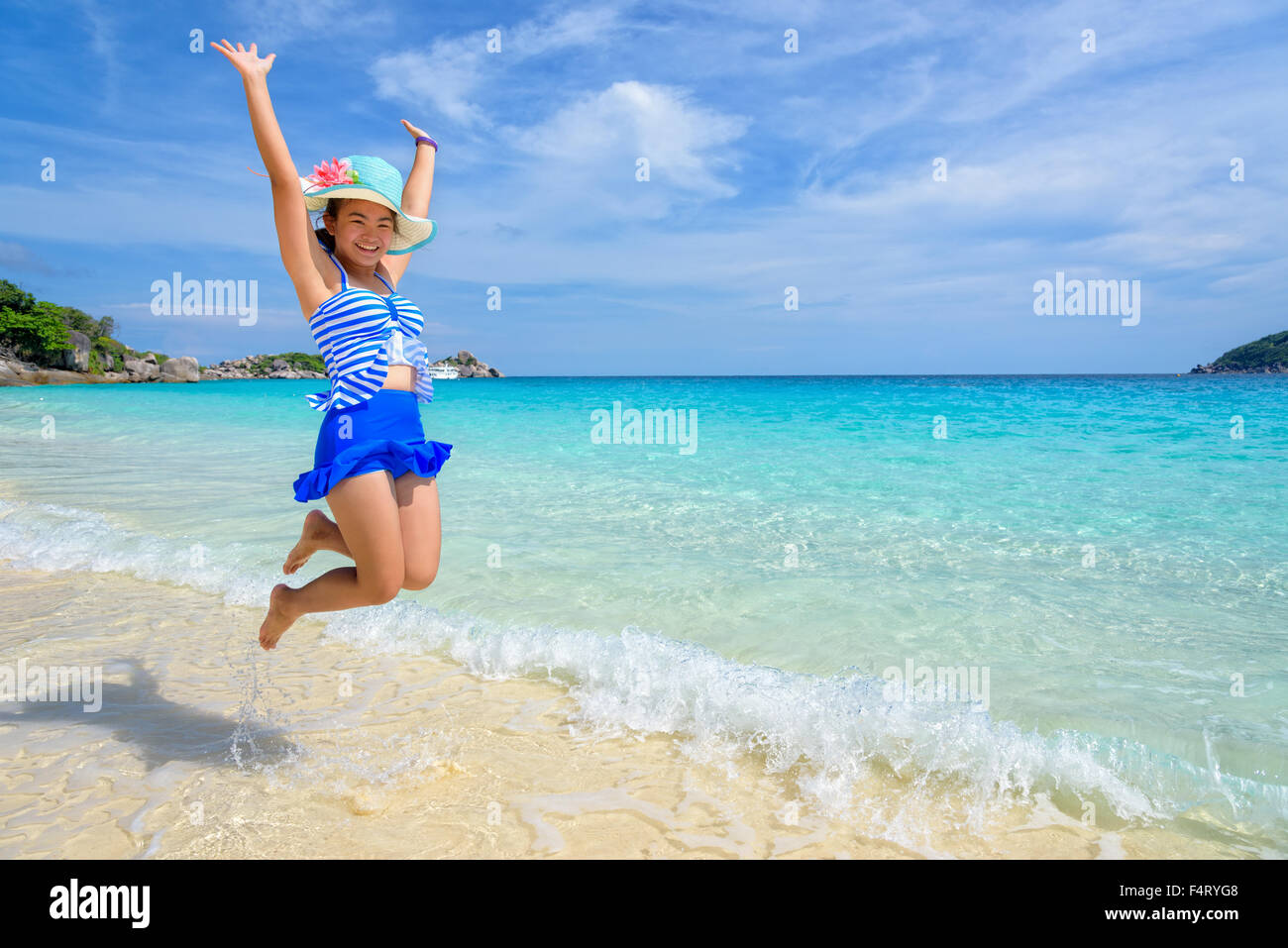 Fille de tourisme dans un maillot rayé blanc bleu sautant avec plaisir sur la belle plage et la mer en été à l'île de Koh Miang Islan Banque D'Images