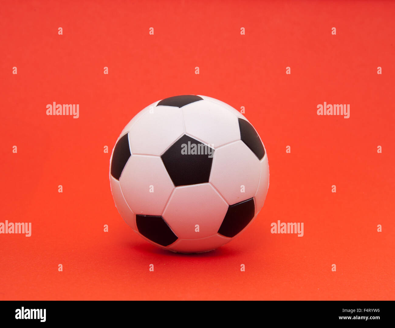 Ballon de soccer sur fond rouge Banque D'Images