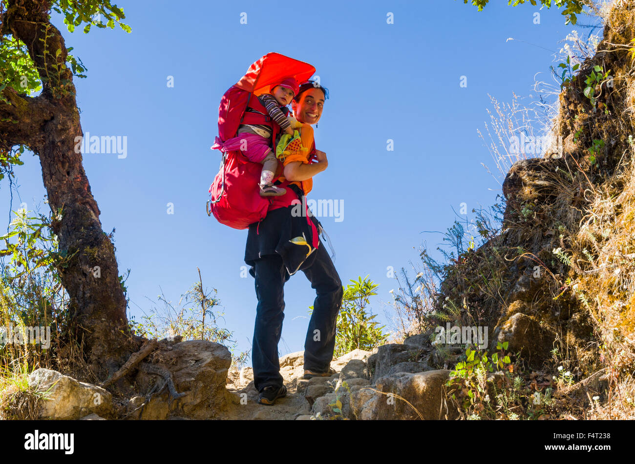 Femme touristiques portant son petit enfant dans un rack sur le dos, la marche à pied et à dos Banque D'Images