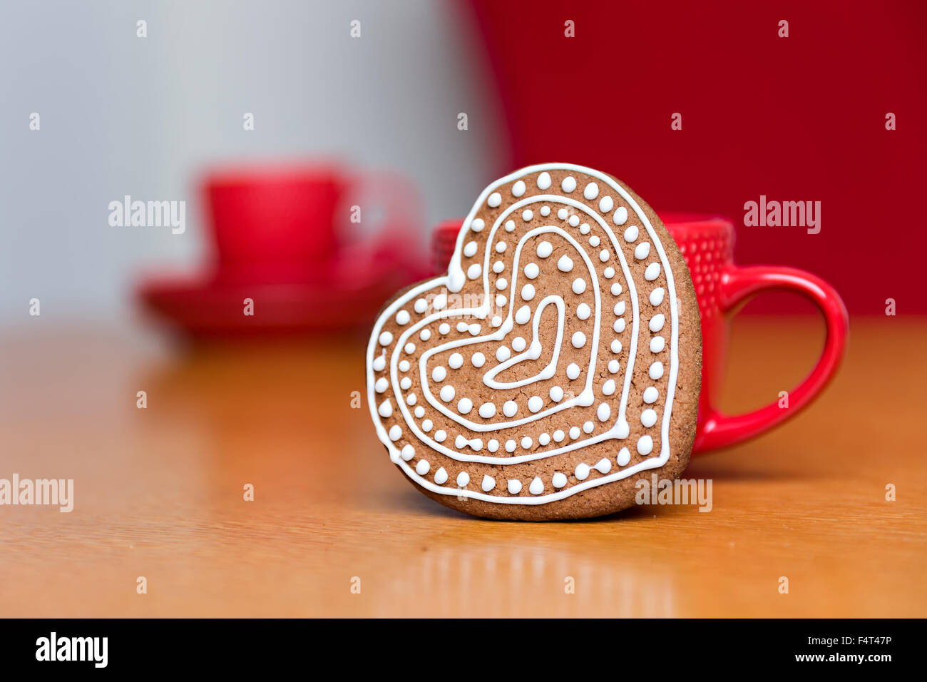 Gingerbread cookie standing next to red cup Banque D'Images