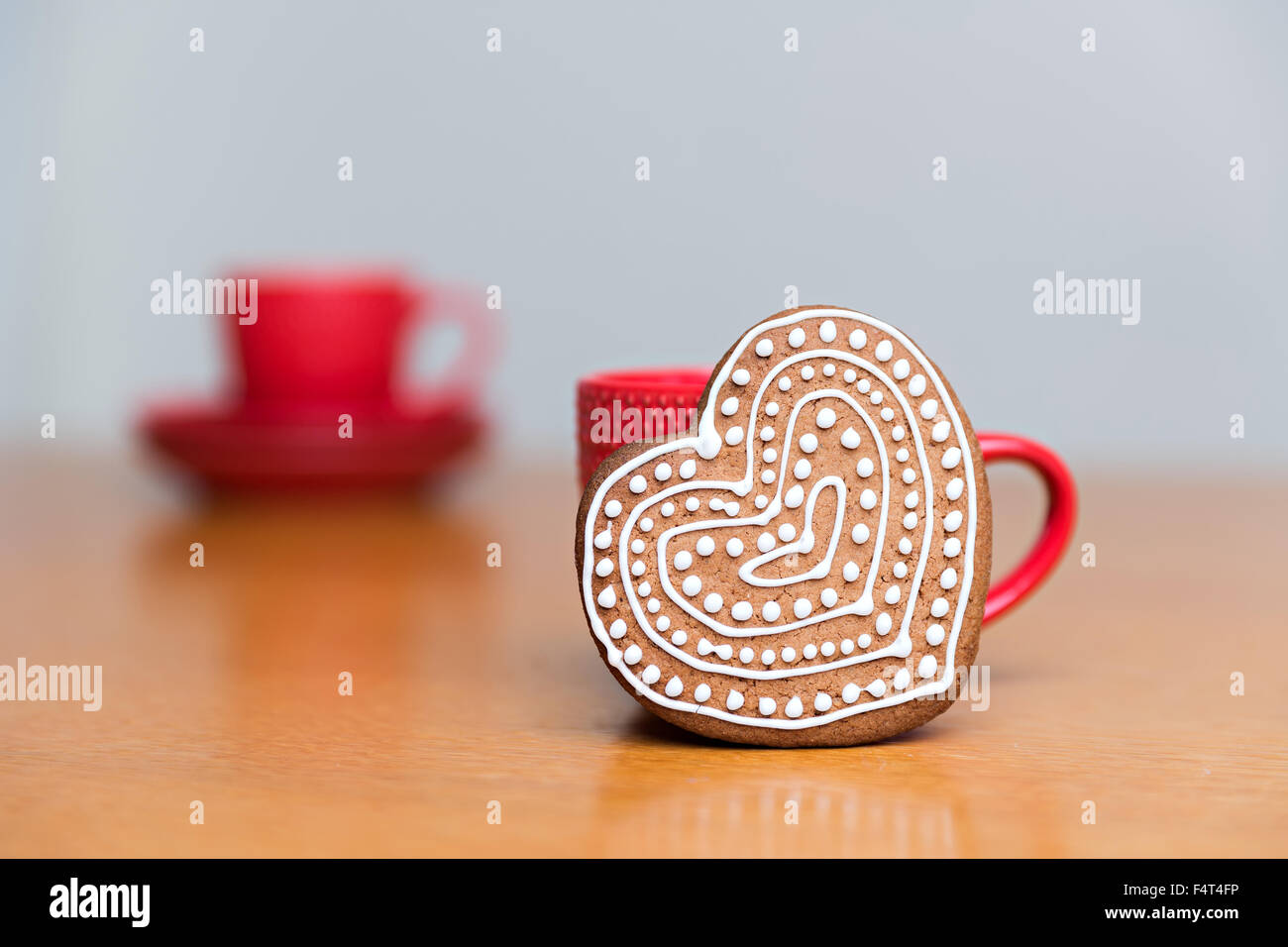 Gingerbread cookie standing next to red cup Banque D'Images