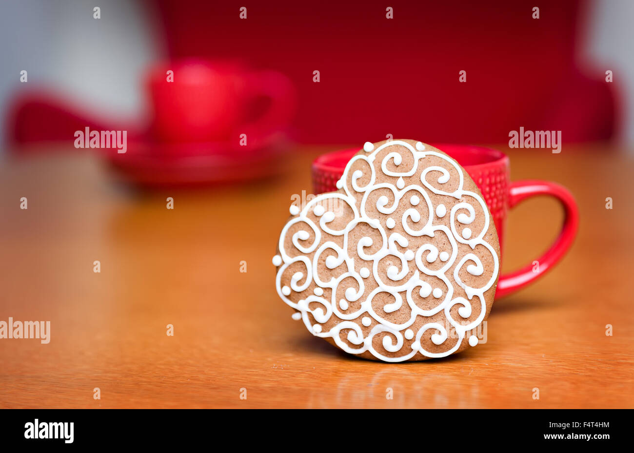 Gingerbread cookie standing next to red cup Banque D'Images