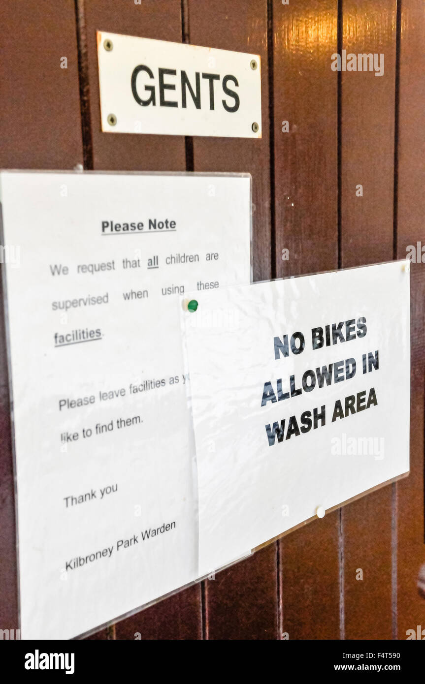 Panneau disant 'Non vélos autorisés dans la zone de lavage' sur la porte d'une toilettes hommes. Banque D'Images
