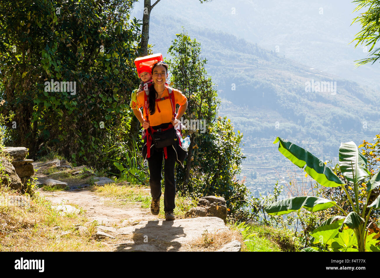 Femme touristiques portant son petit enfant dans un rack sur son dos, trekking Banque D'Images