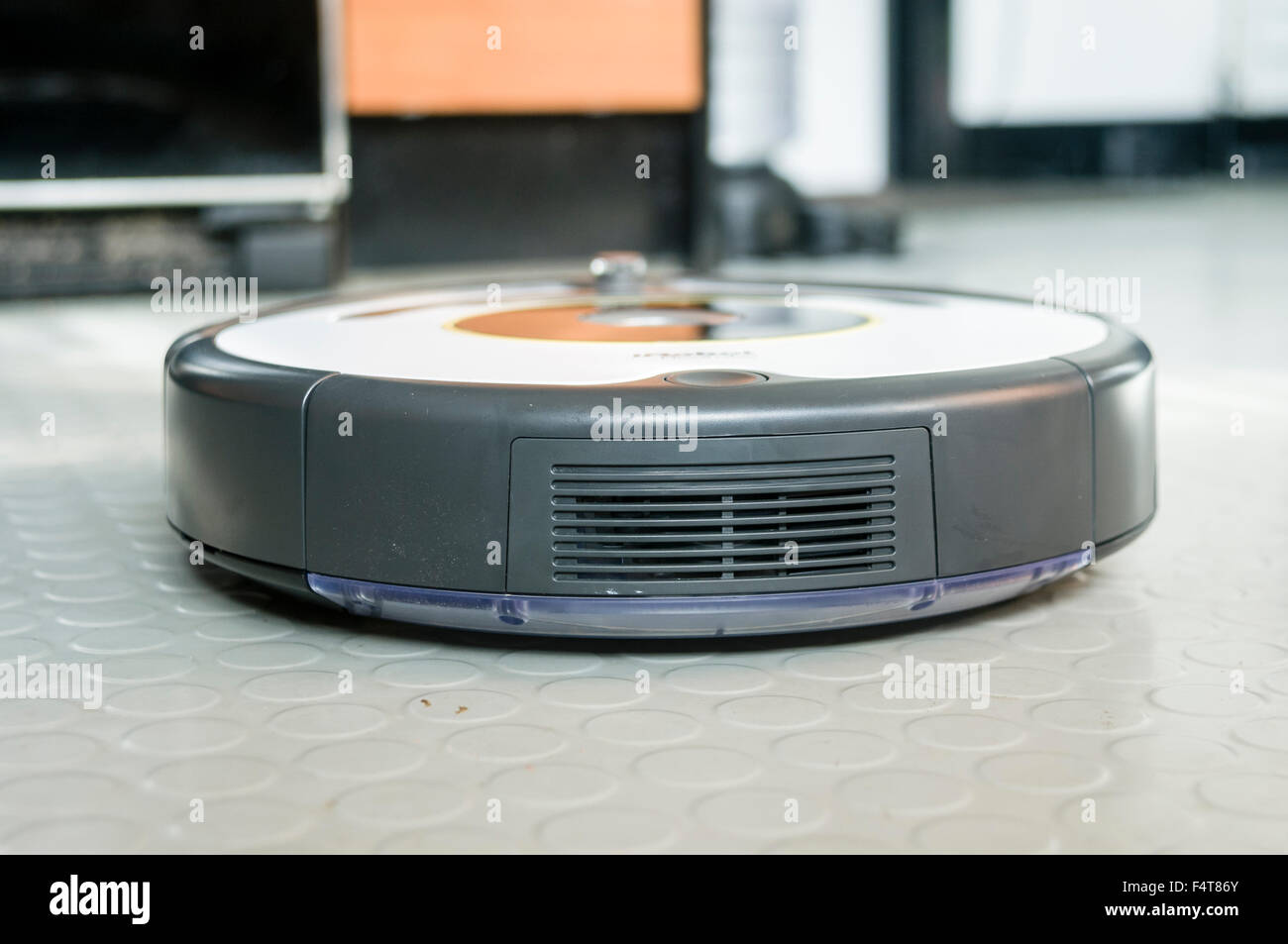 Un aspirateur robot iRobot Roomba le nettoyage d'un vinyle en caoutchouc de plancher de cuisine Banque D'Images