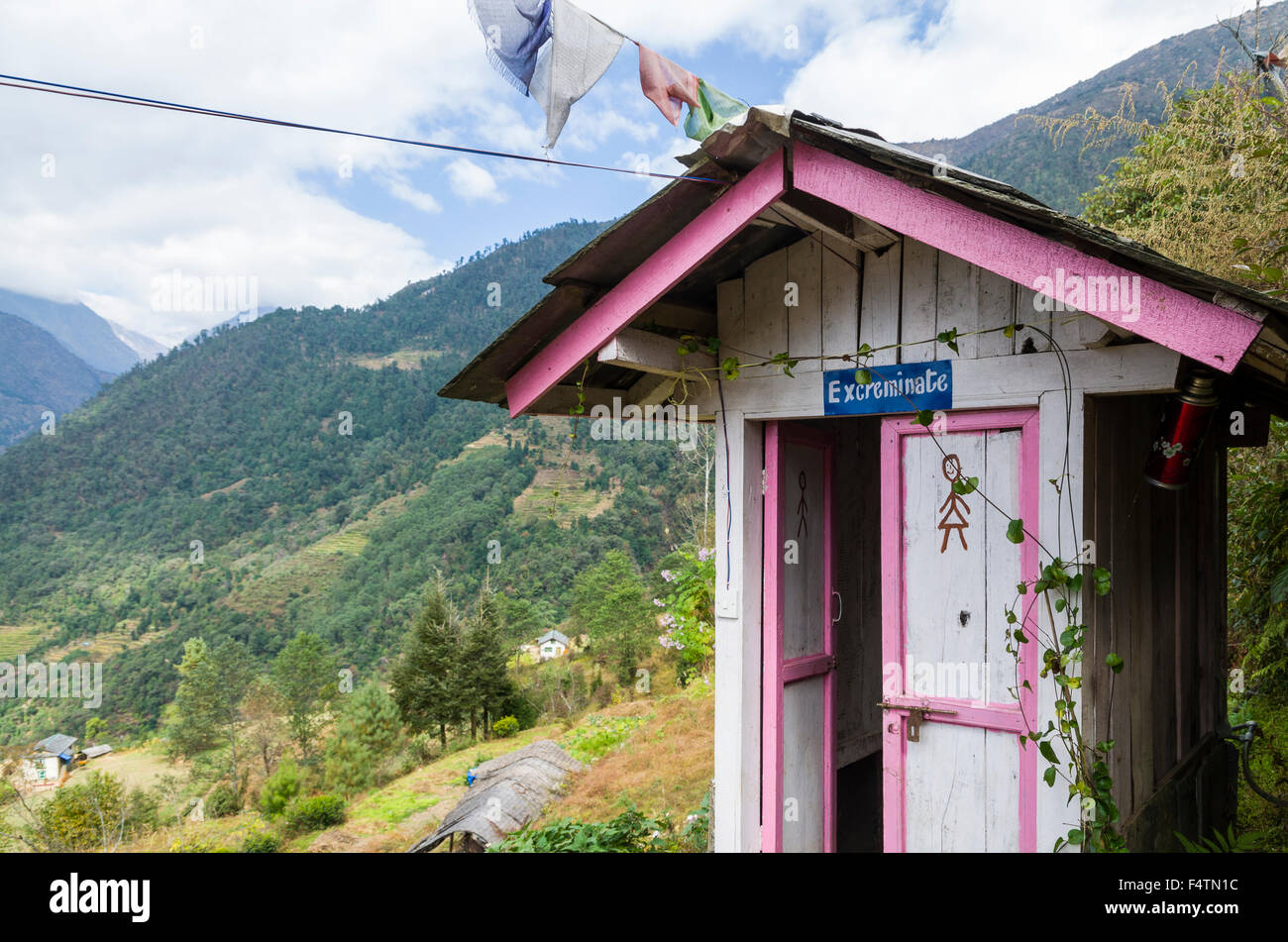 Maison de toilette peinte en rose et blanc, Excreminate écrit au-dessus de la porte Banque D'Images Maison de toilette peinte en rose et blanc, Excreminate écrit au-dessus de la porte Banque D'Images