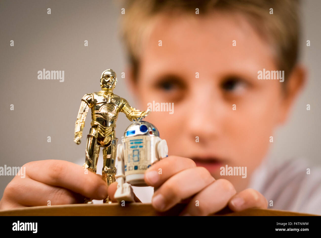 Un garçon jouant avec des années 1970 chiffres de Star Wars Banque D'Images