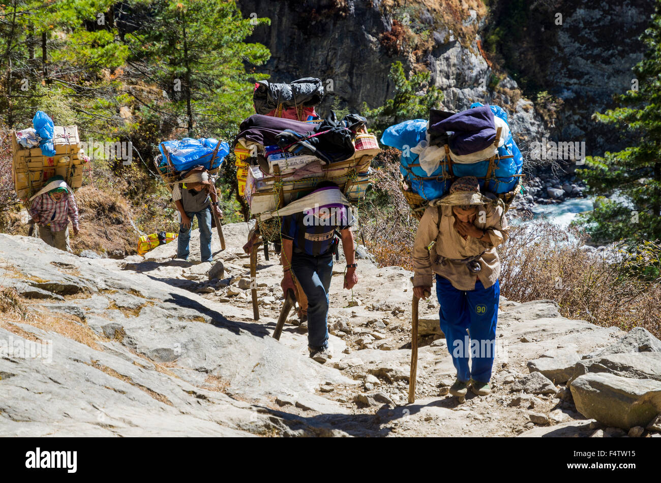 Porteurs transportant de lourdes à charger une voie ascendante au-dessus de Namche Bazar (3,440 m), la base pour le trekking et l'alpinisme en solo Banque D'Images