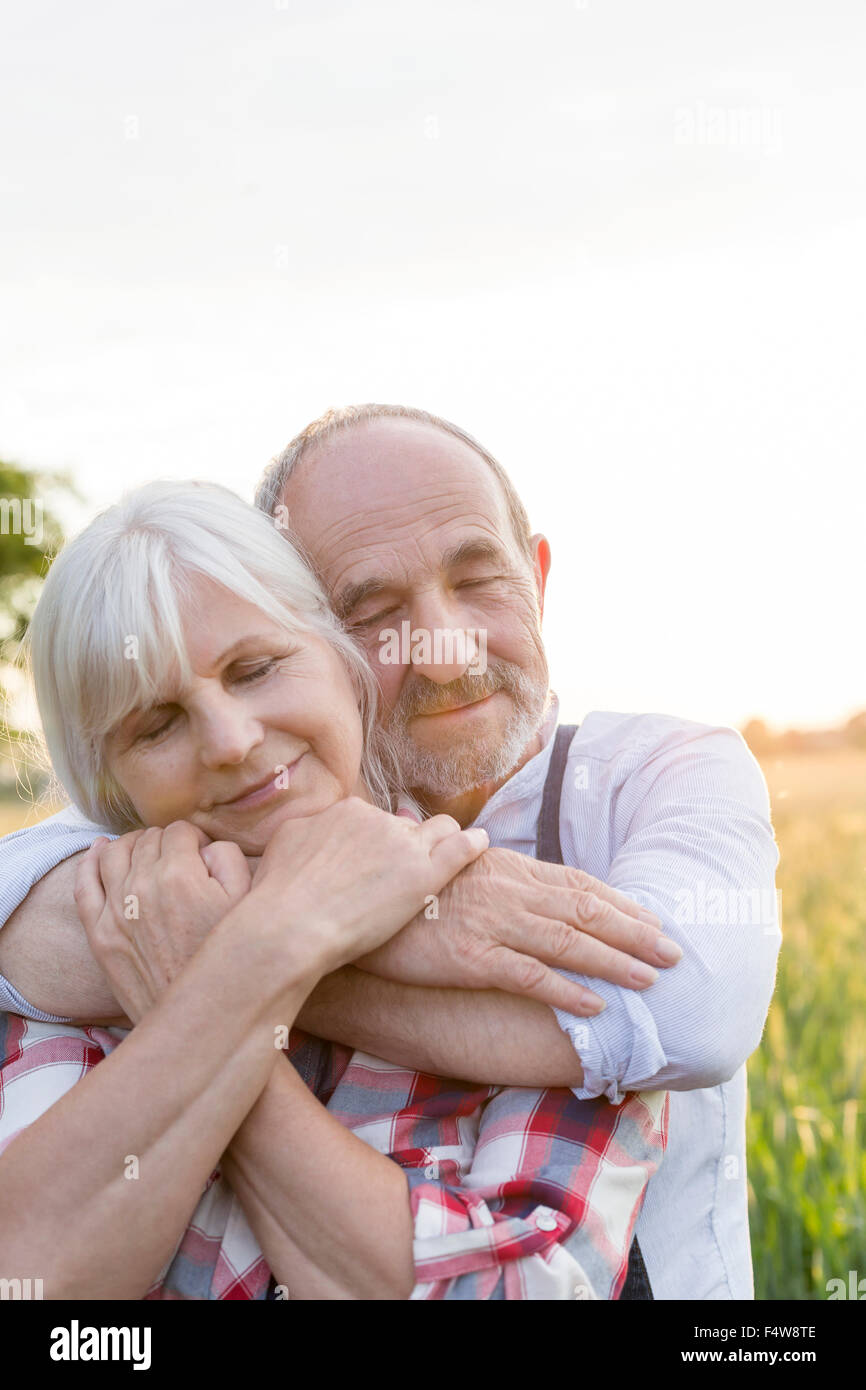 Close up portrait of senior couple hugging sereine avec les yeux fermé Banque D'Images