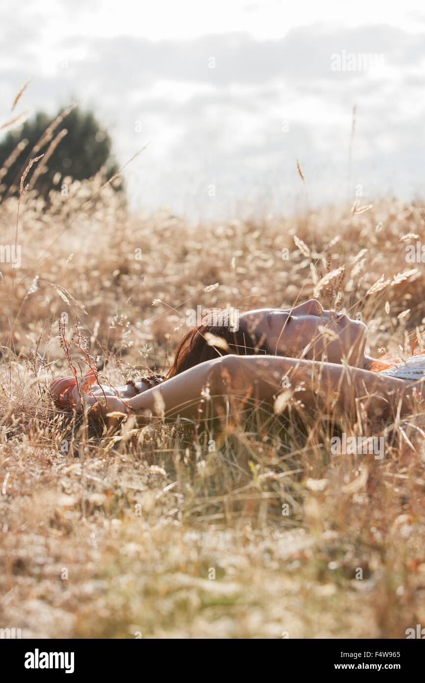 Serene woman sleeping in rural field Banque D'Images