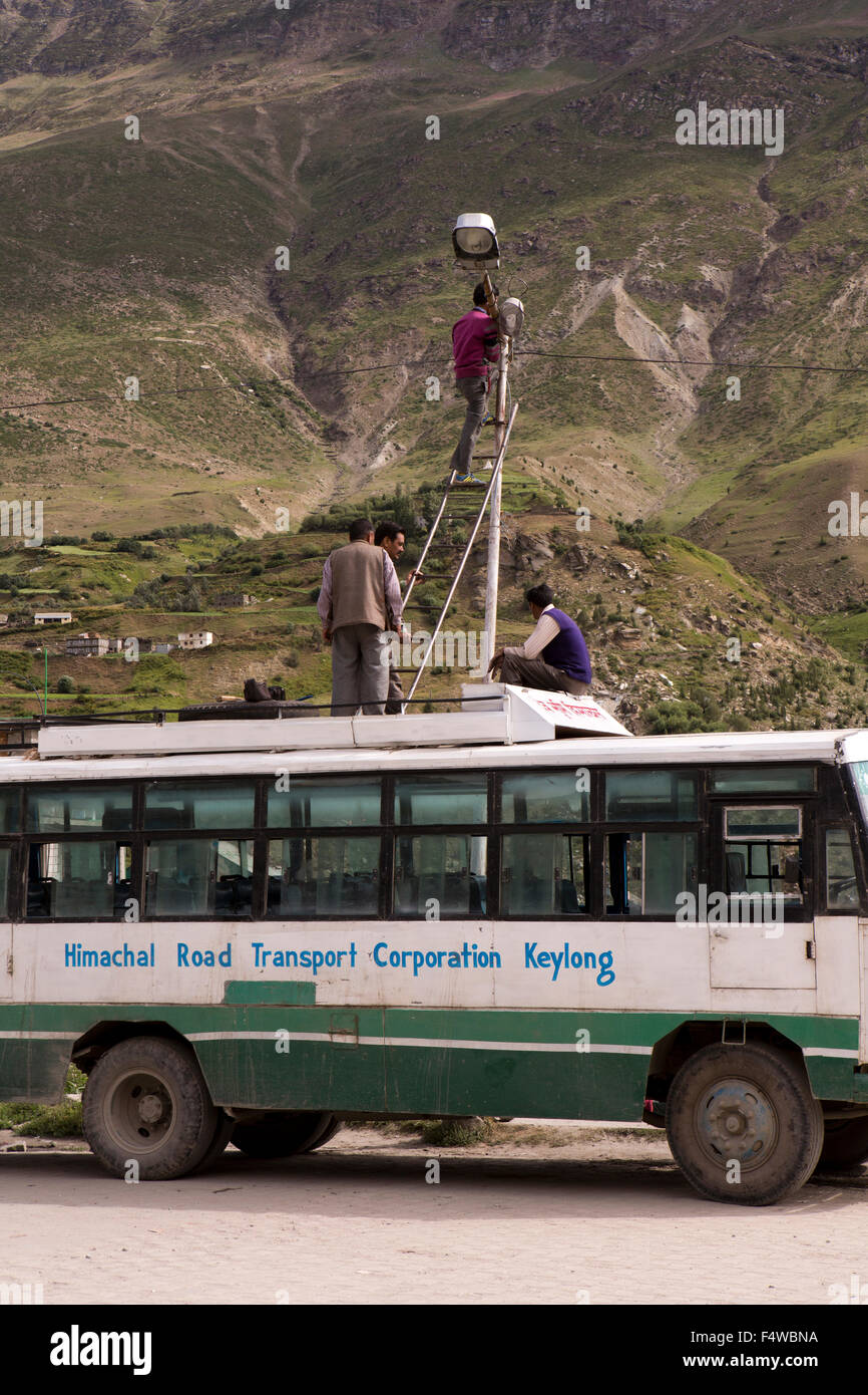 L'Inde, l'Himachal Pradesh, Lahaul et Spiti, Keylong Bus Stand, les hommes à l'aide de bus comme plate-forme pour réparer l'éclairage public Banque D'Images