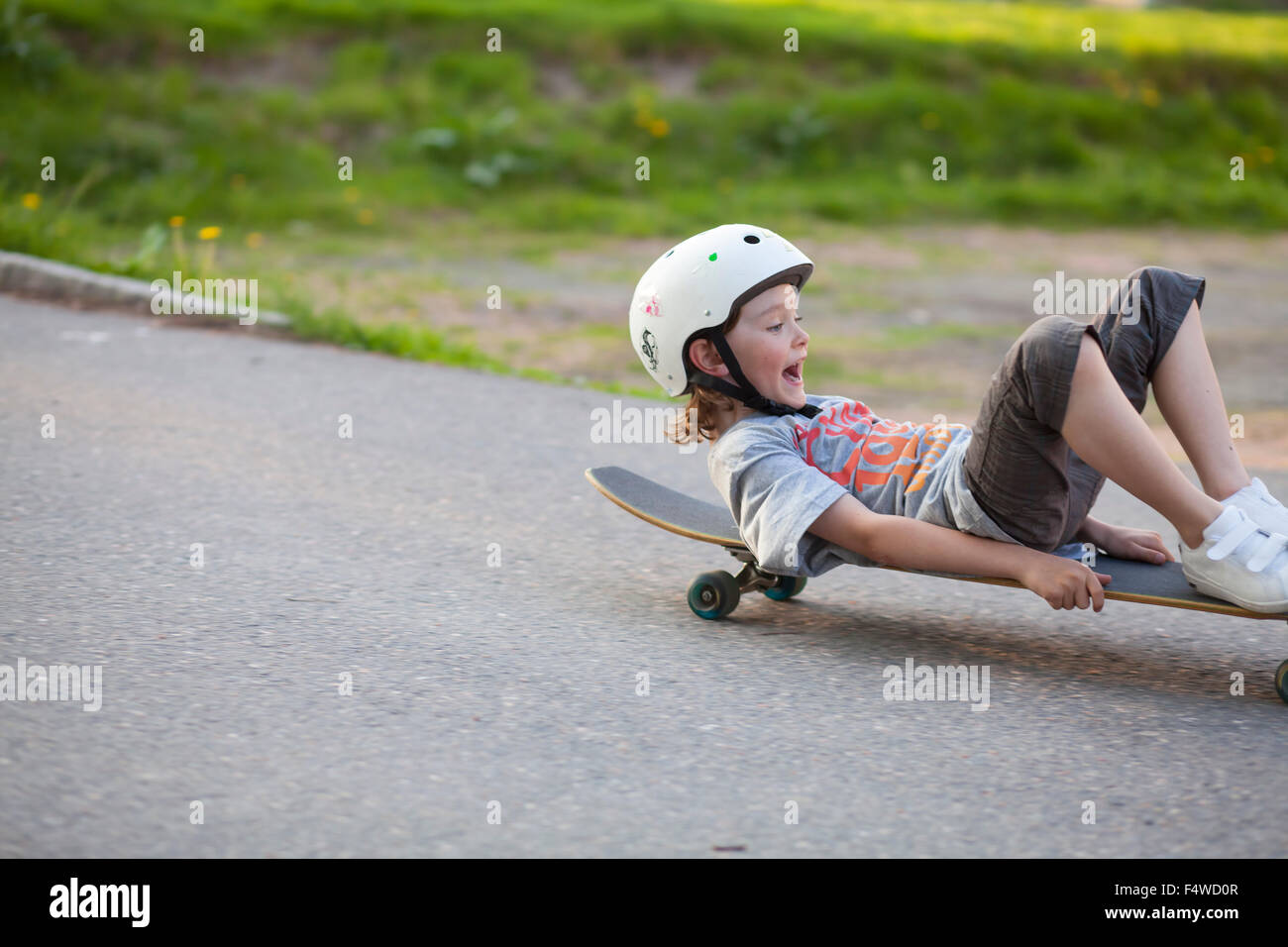 La Suède, Vastergotland, Lerum, Boy (8-9), le glissement vers le bas sur la rue skateboard Banque D'Images