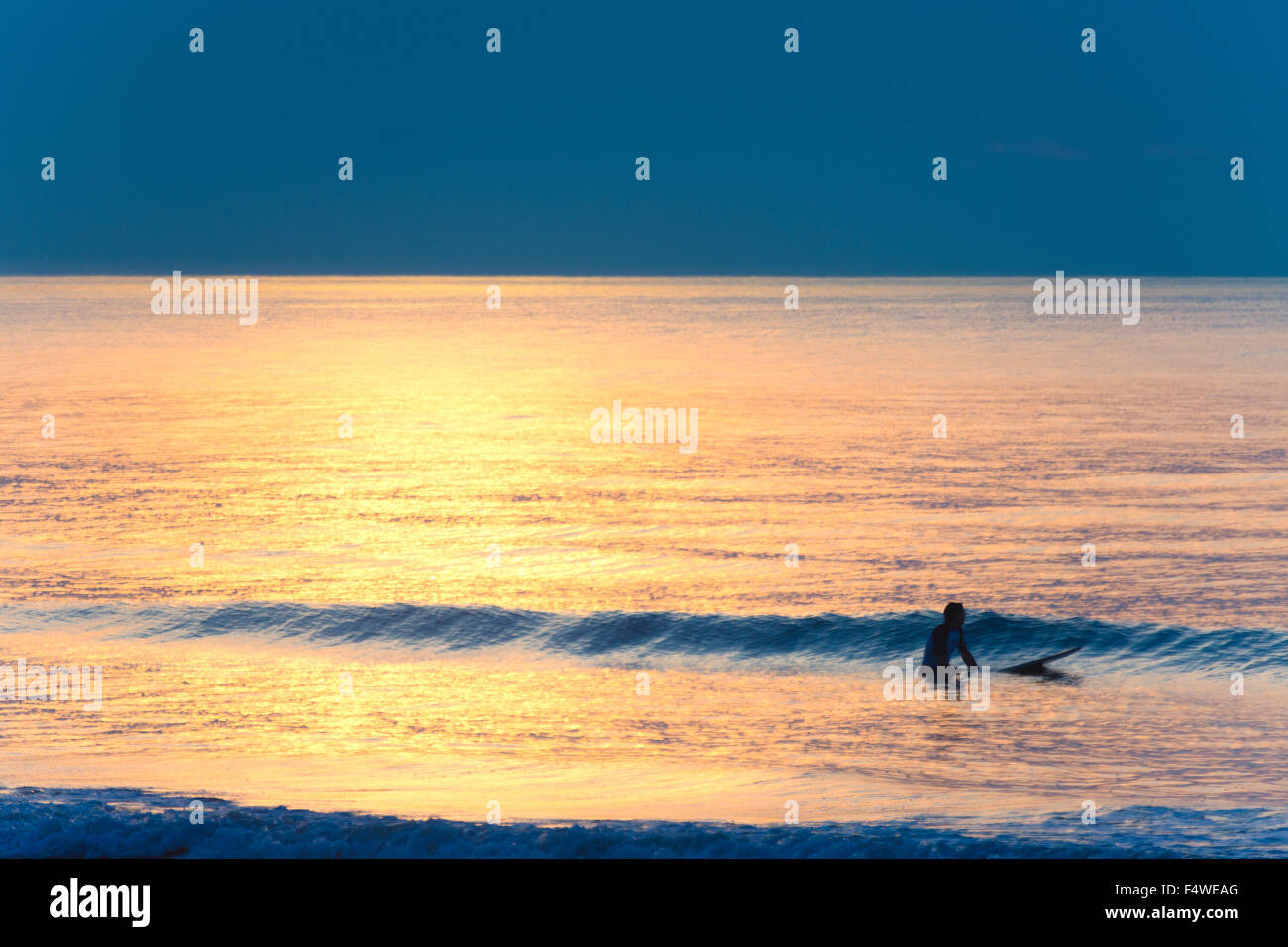 USA, Caroline du Sud, Charleston Comté, Isle of Palms, surfer les vagues attendent au coucher du soleil Banque D'Images