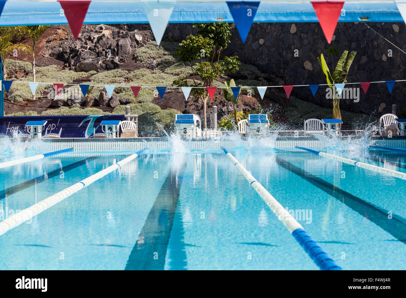 Splashs sur la surface d'une piscine après raceing nageurs ont plongé. Banque D'Images