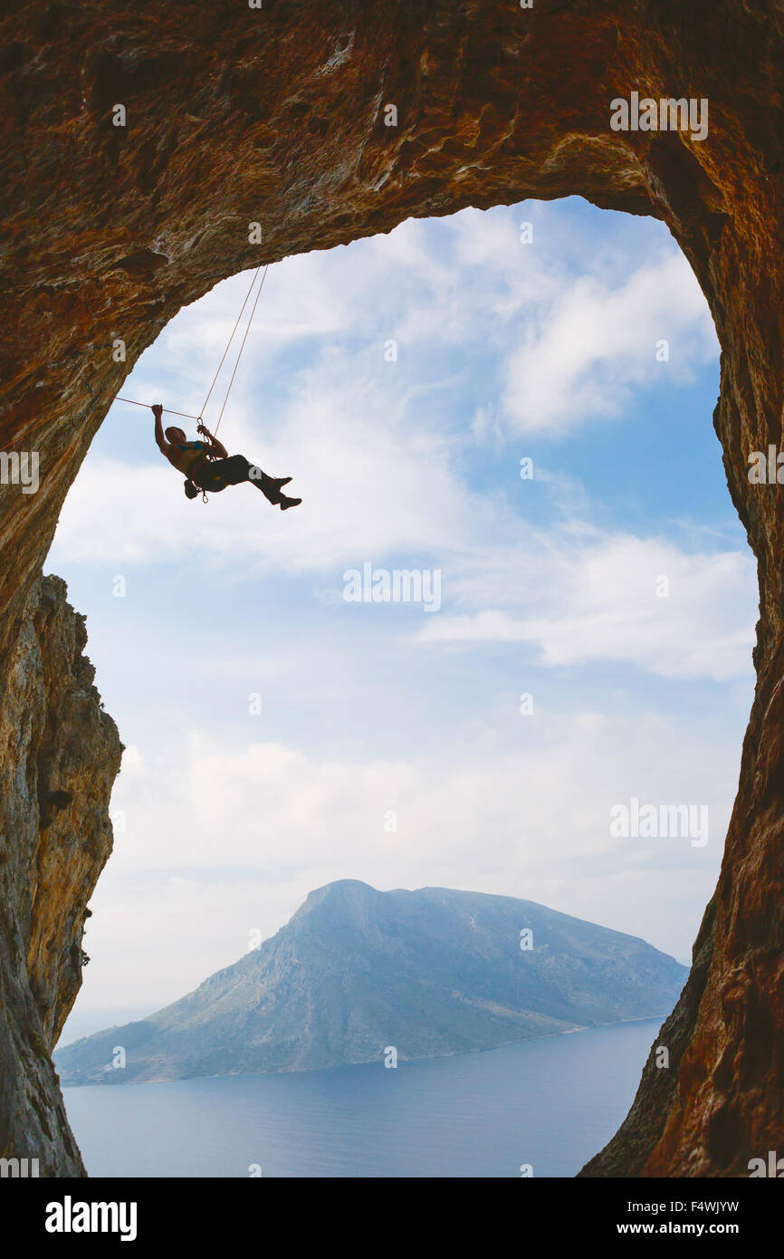 Grèce, Îles du Dodécanèse, Kalymnos, alpinisme hanging off arche naturelle Banque D'Images