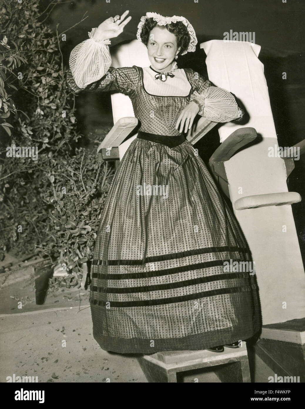 L'actrice Américaine Lynn Bari tente une chaise spéciale pendant une pause de tournage du film 'chant de la jeunesse" Banque D'Images