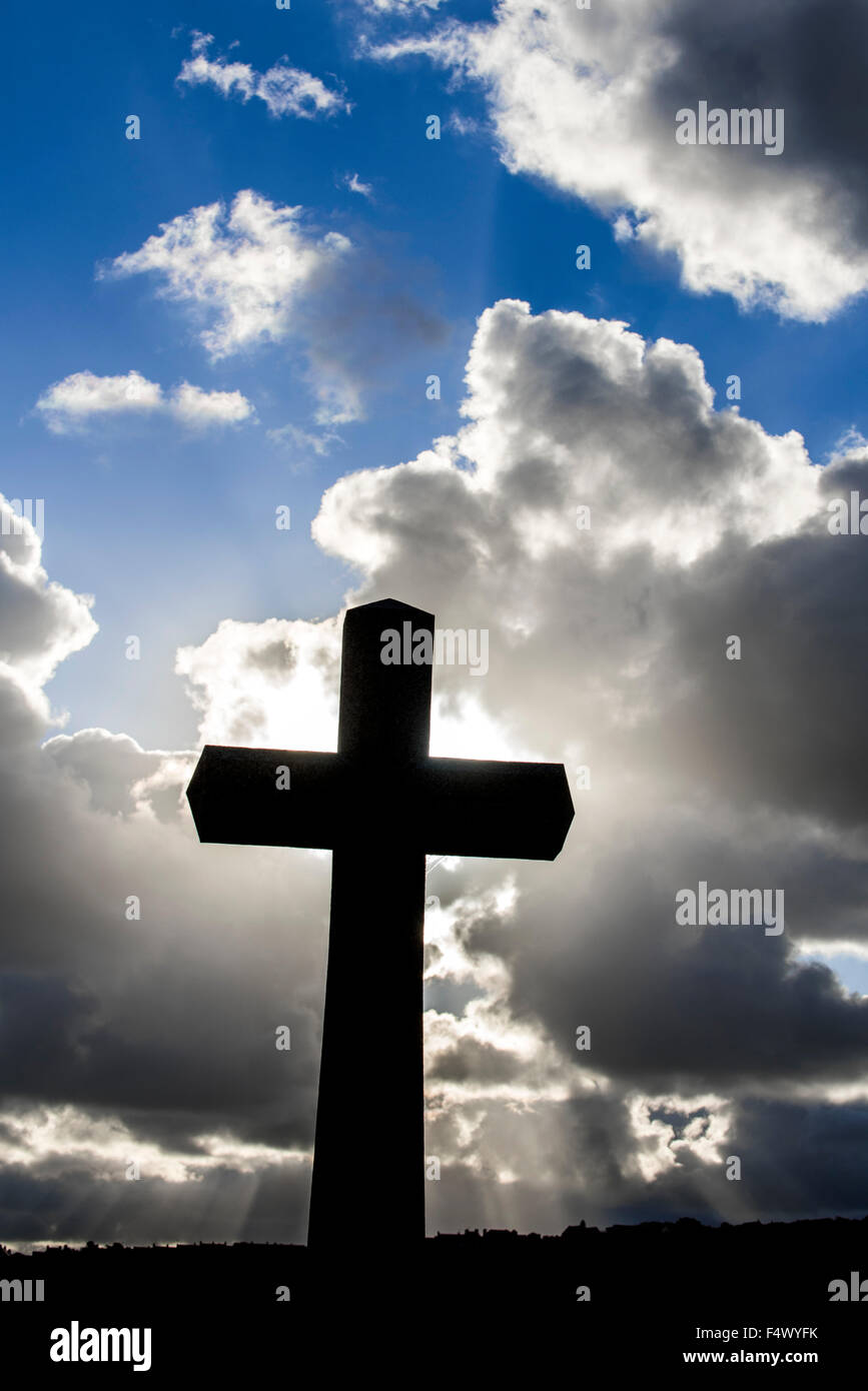 Cross silhouetted against cloudy sky Banque D'Images