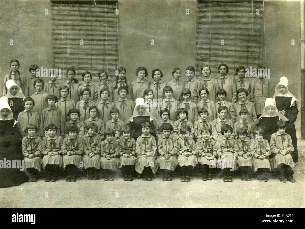 Photo classe de filles de l'école religieuse primaire avec un tablier gris, Italie Banque D'Images