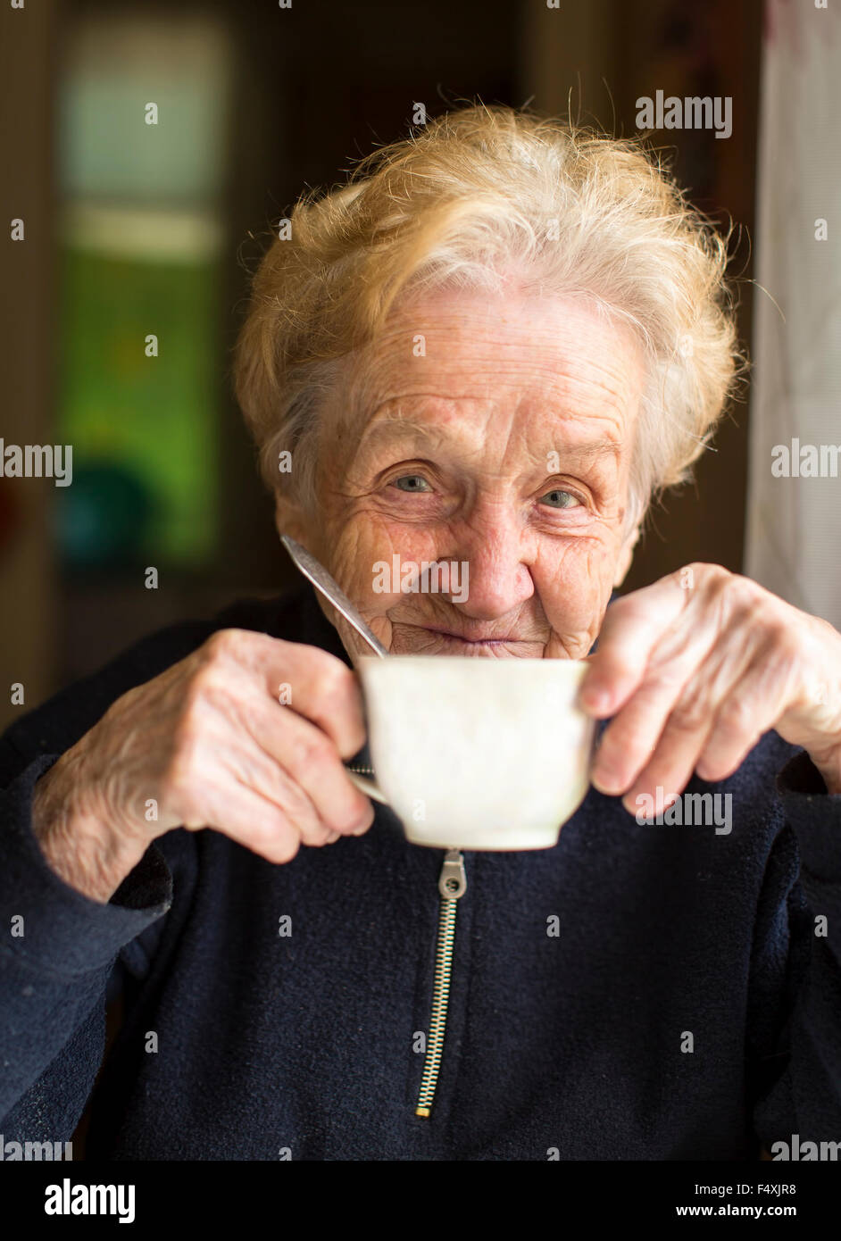 Vieille Femme assise à boire le thé, un portrait d'une vieille femme, grand-mère. Banque D'Images