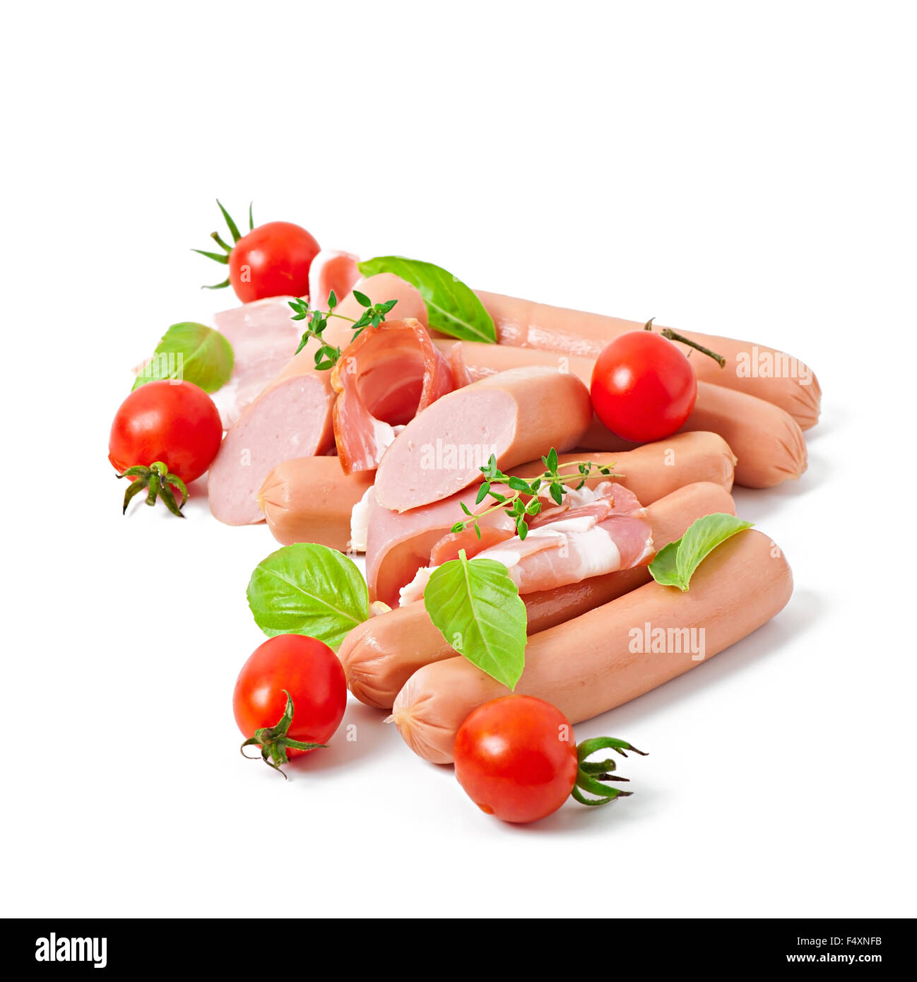 Les viandes délicates (saucisse et jambon) décorées avec des tomates et basilic isolé sur fond blanc Banque D'Images