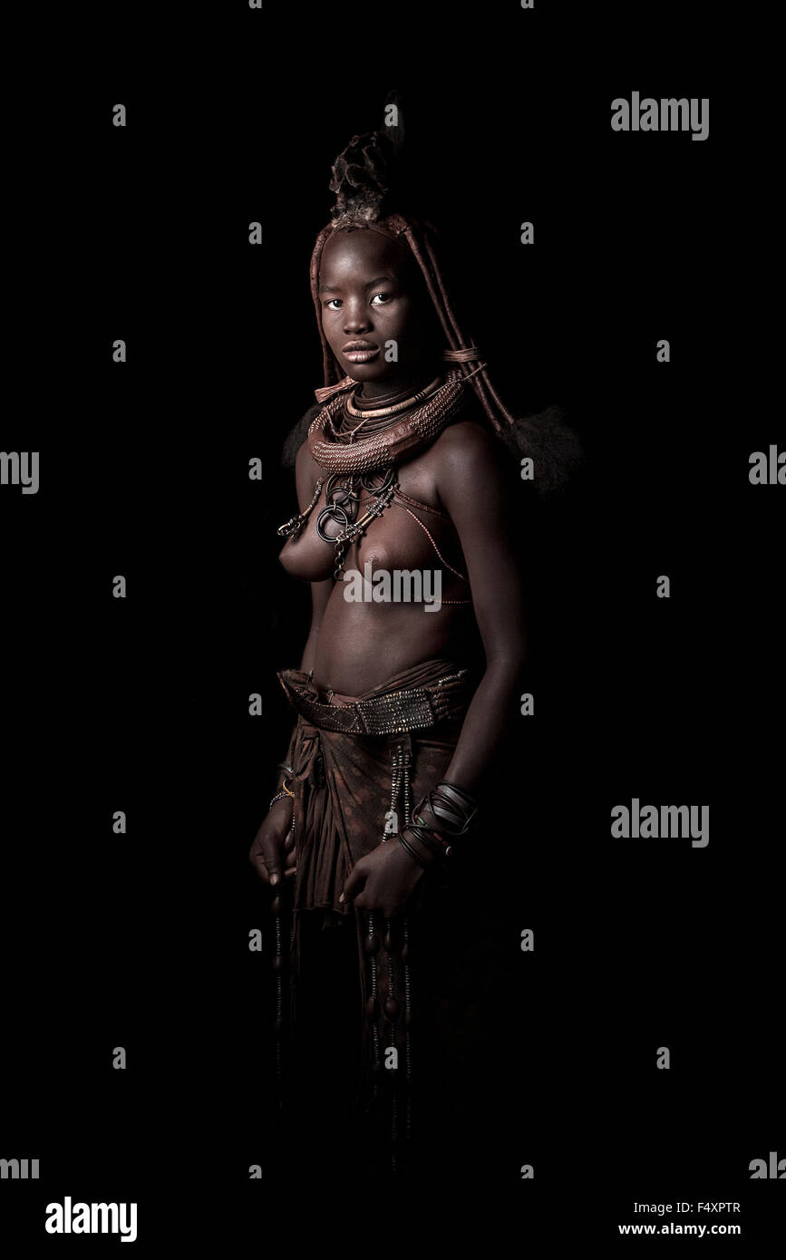 Une femme Himba affiche sa robe traditionnelle et leurs parures. Banque D'Images