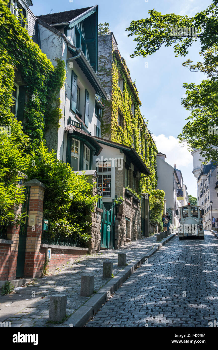 Rangée de maisons, façades couvertes de lierre, train touristique, Montmartre, Paris, France Banque D'Images