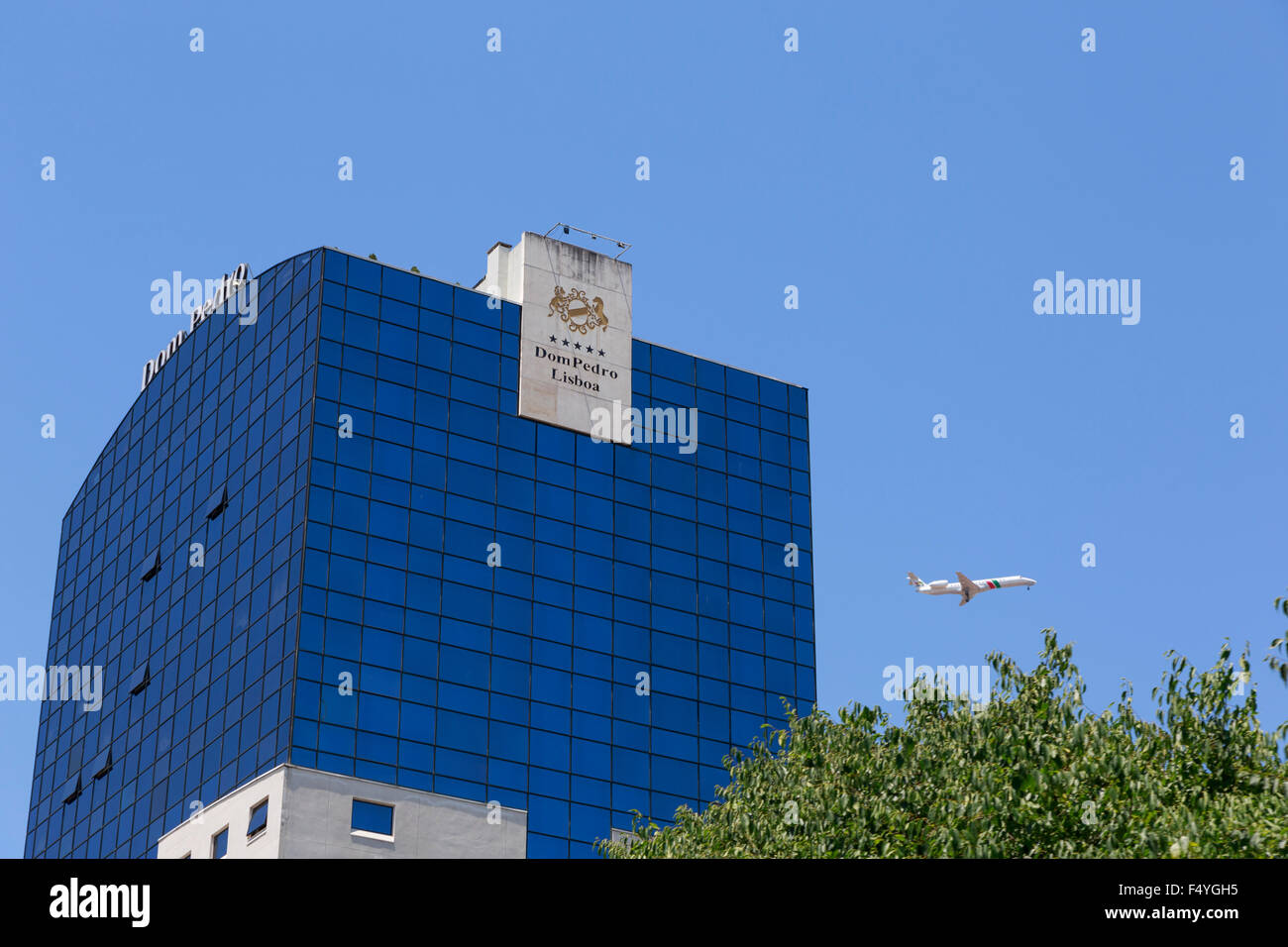Étages supérieurs de l'hôtel Dom Pedro en verre Hotel Lisbonne avec une compagnie aérienne PGA Portugalia avion volant au cours des Banque D'Images
