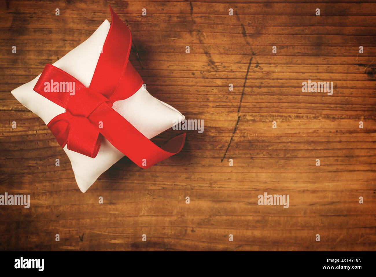 Cadeau de Noël enroulé et attaché avec un ruban rouge sur de vieux bois de chêne 24, Vue de dessus, l'espace de copie aux couleurs rétro, selective focus Banque D'Images