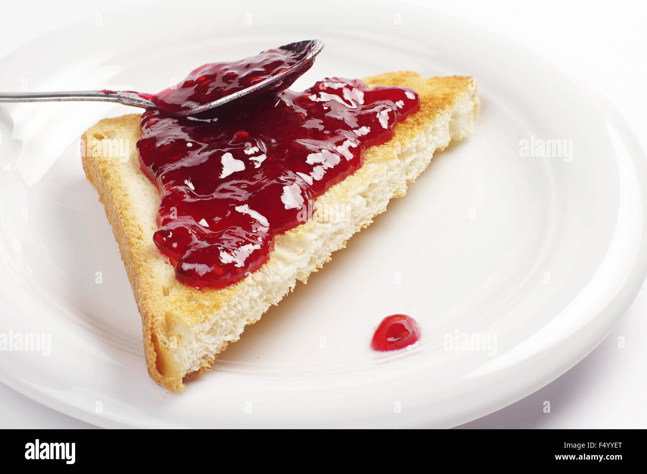 Toast tranche de pain avec de la confiture de framboises on white plate Banque D'Images