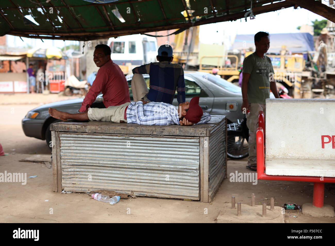 L'homme de dormir sur un sol en bois/métal de construction à Sisophon, Cambodge Banque D'Images