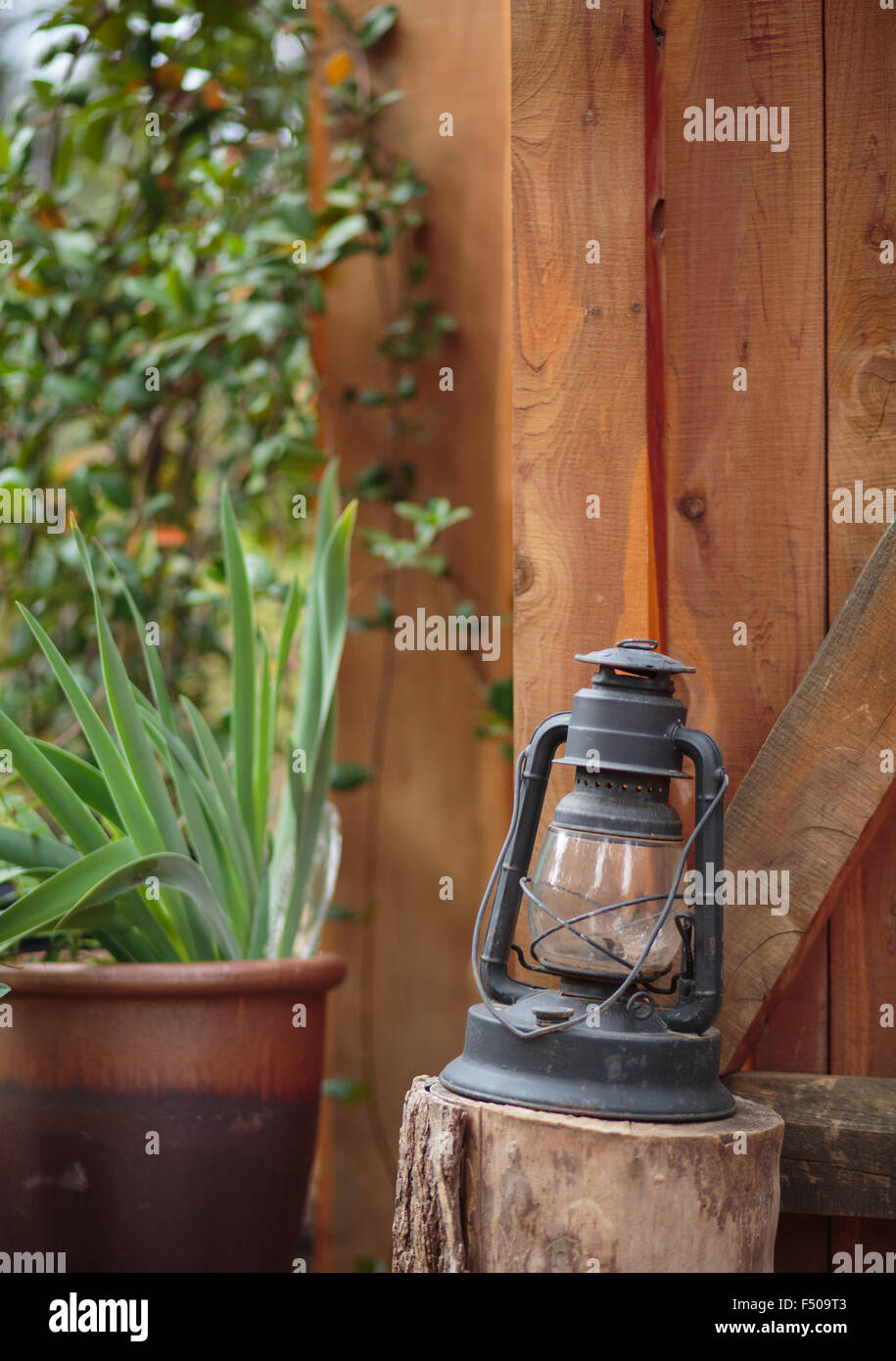 Une vieille lanterne à gaz sur une souche devant un chalet en bois Banque D'Images