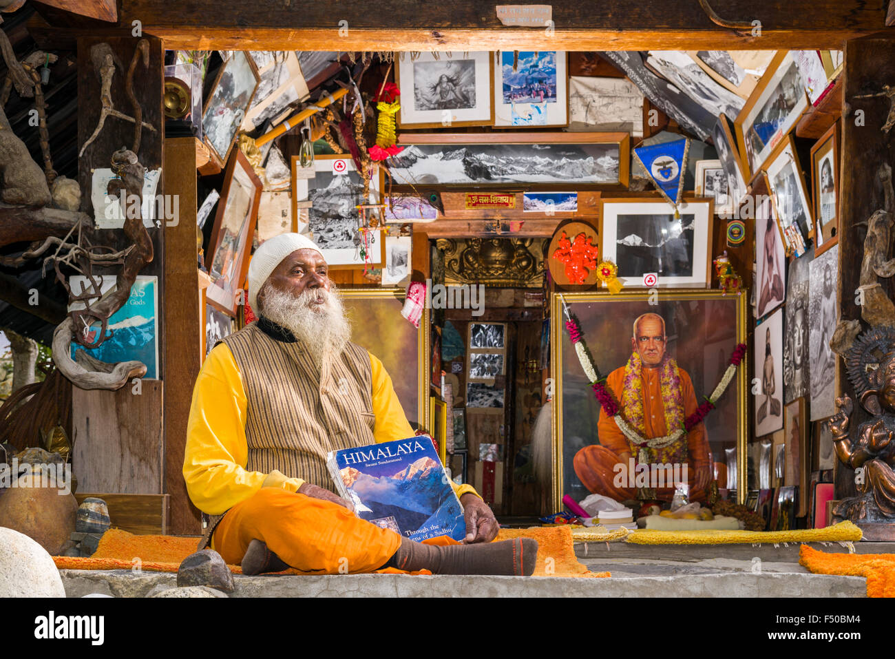 Swami sundaranand, un célèbre sadhu, yogi et photographe, est assis en face de sa maison et d'afficher son livre Banque D'Images