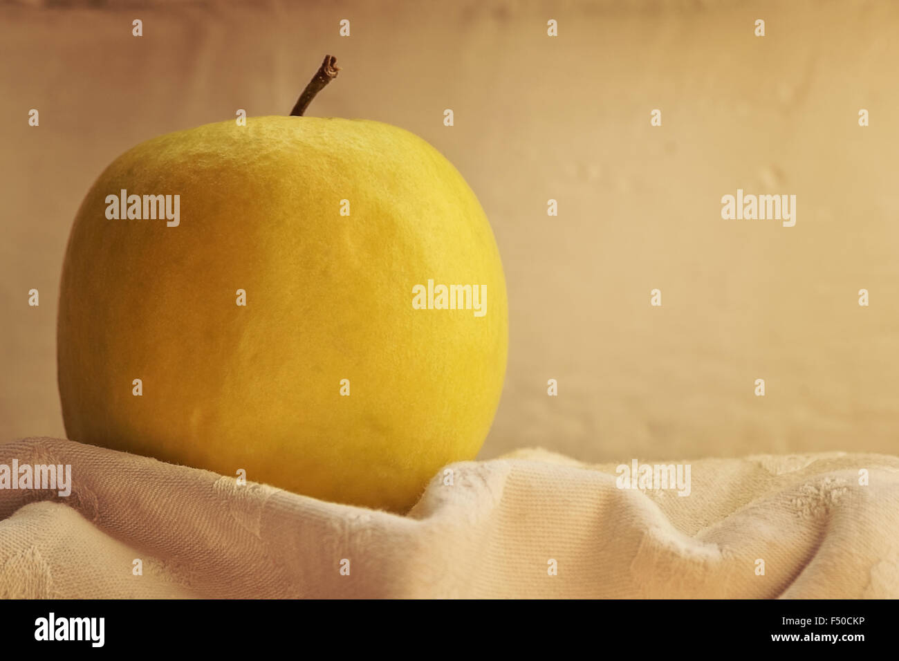 Pomme mûre Jaune sur blanc tissu texturé, close-up. Banque D'Images