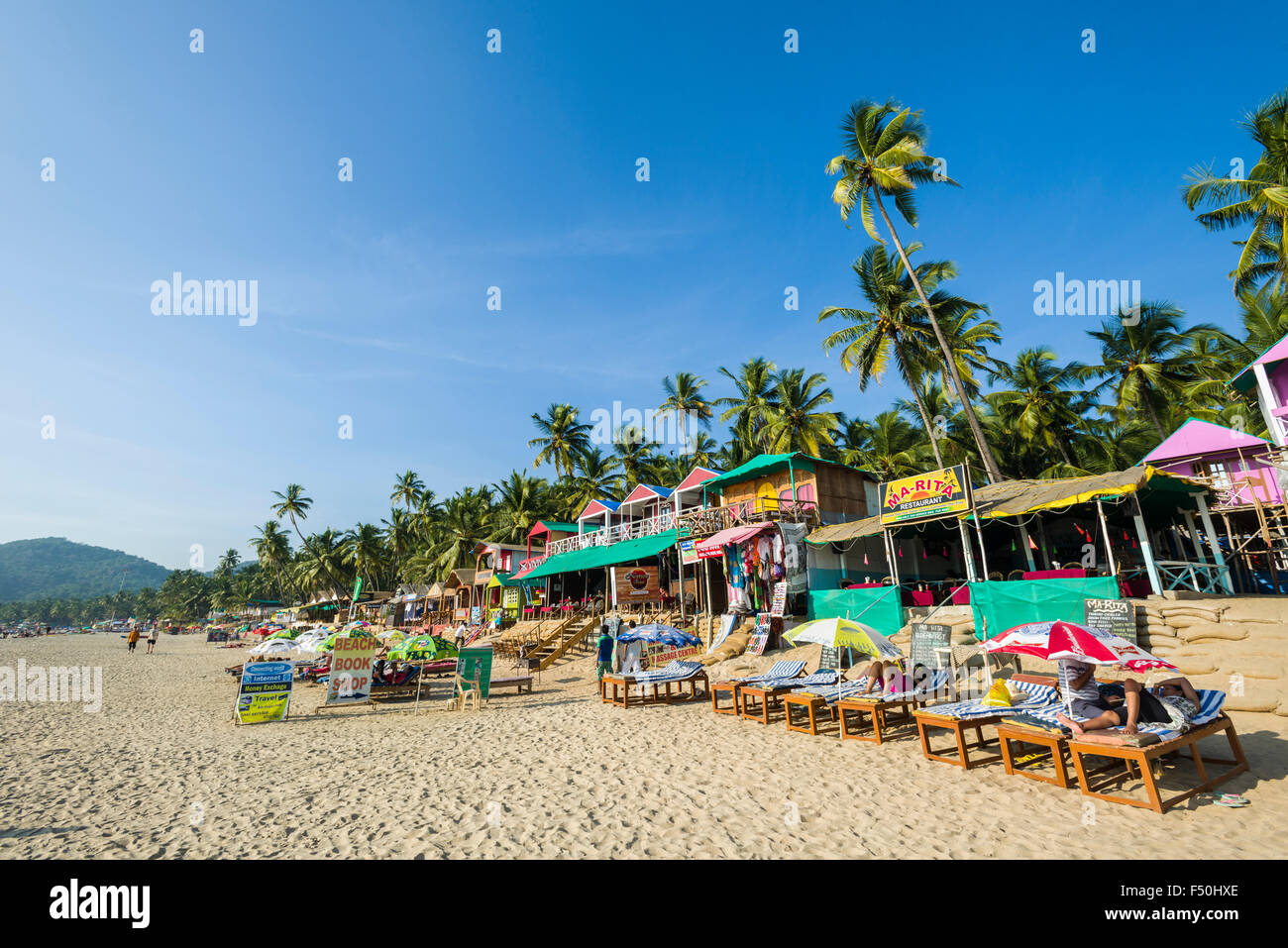 Huttes peintes de couleurs vives à plage de Palolem avec ciel bleu, de palmiers et de sable blanc Banque D'Images